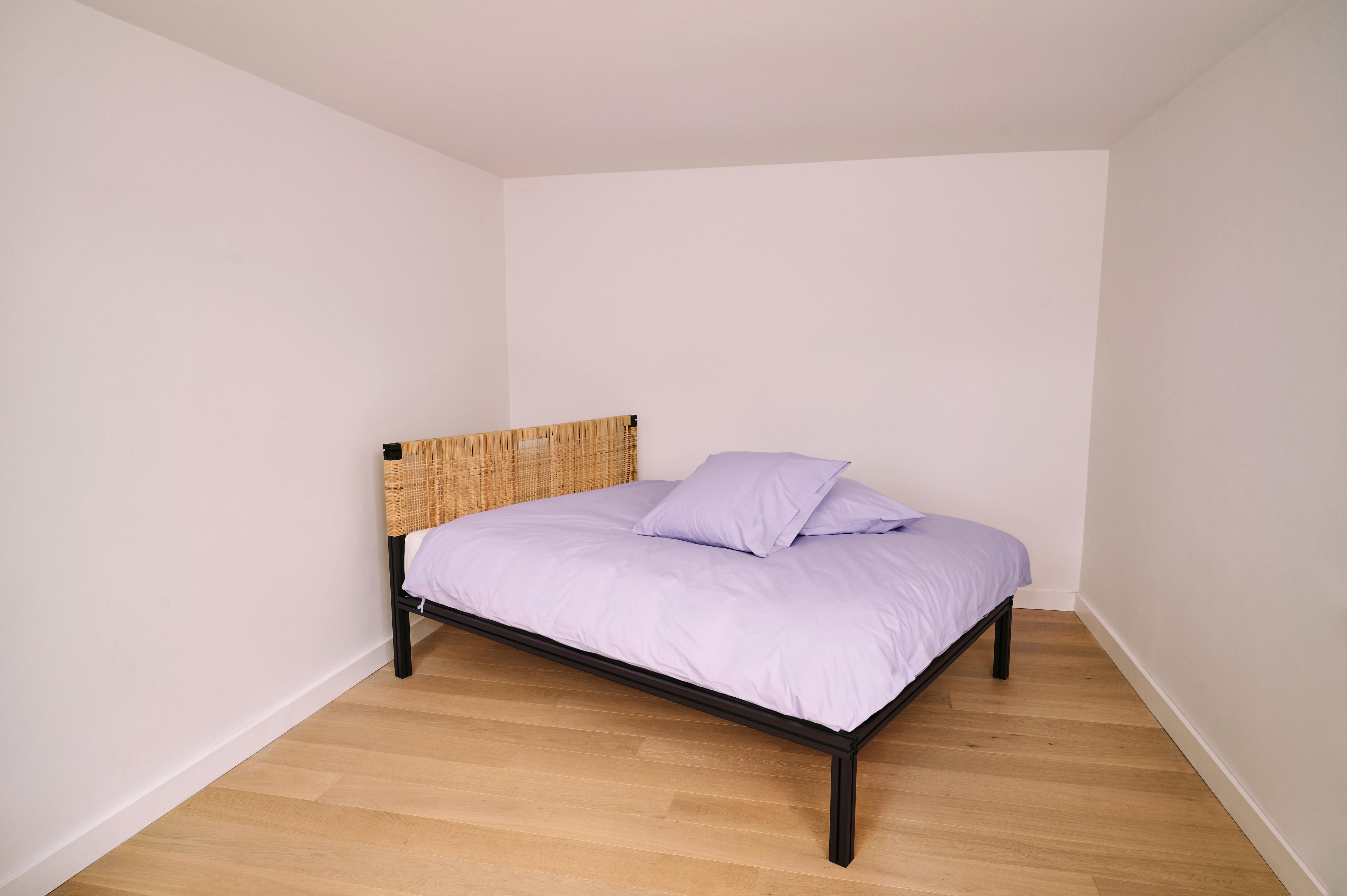 Bed frame made from dark brown anodised aluminium extrusions and a woven cane head board. The shown bed is UK king size with the mattress being 35 off the ground, but all other bed sizes are available. The frame comes with slats.

Furniture designer