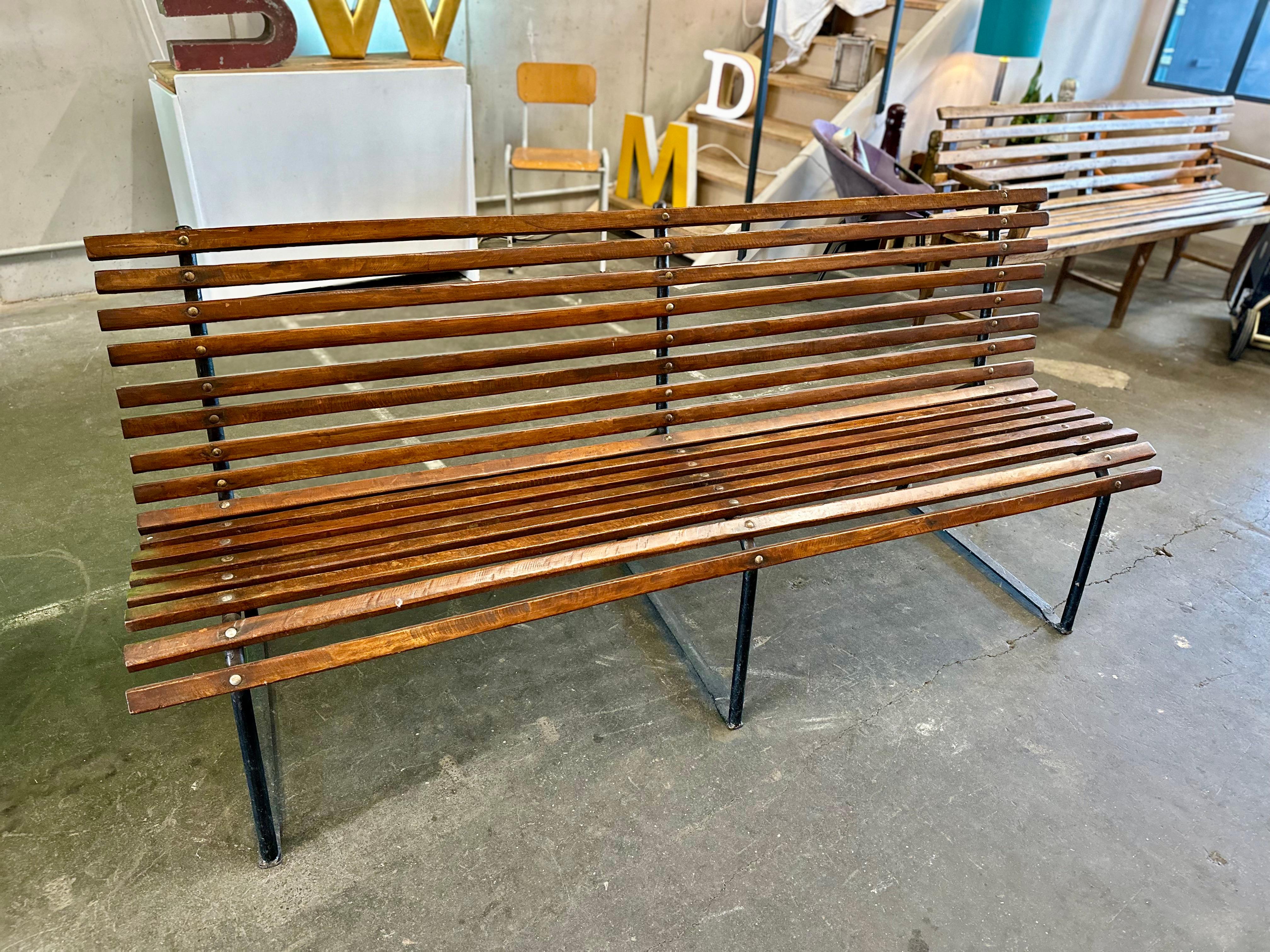 Indulge in timeless seating comfort with our handcrafted dark brown bench dating back to around 1920. The distinctive wooden slats not only lend a charming visual appeal but also carry a beautiful patina, showcasing the marks of bygone