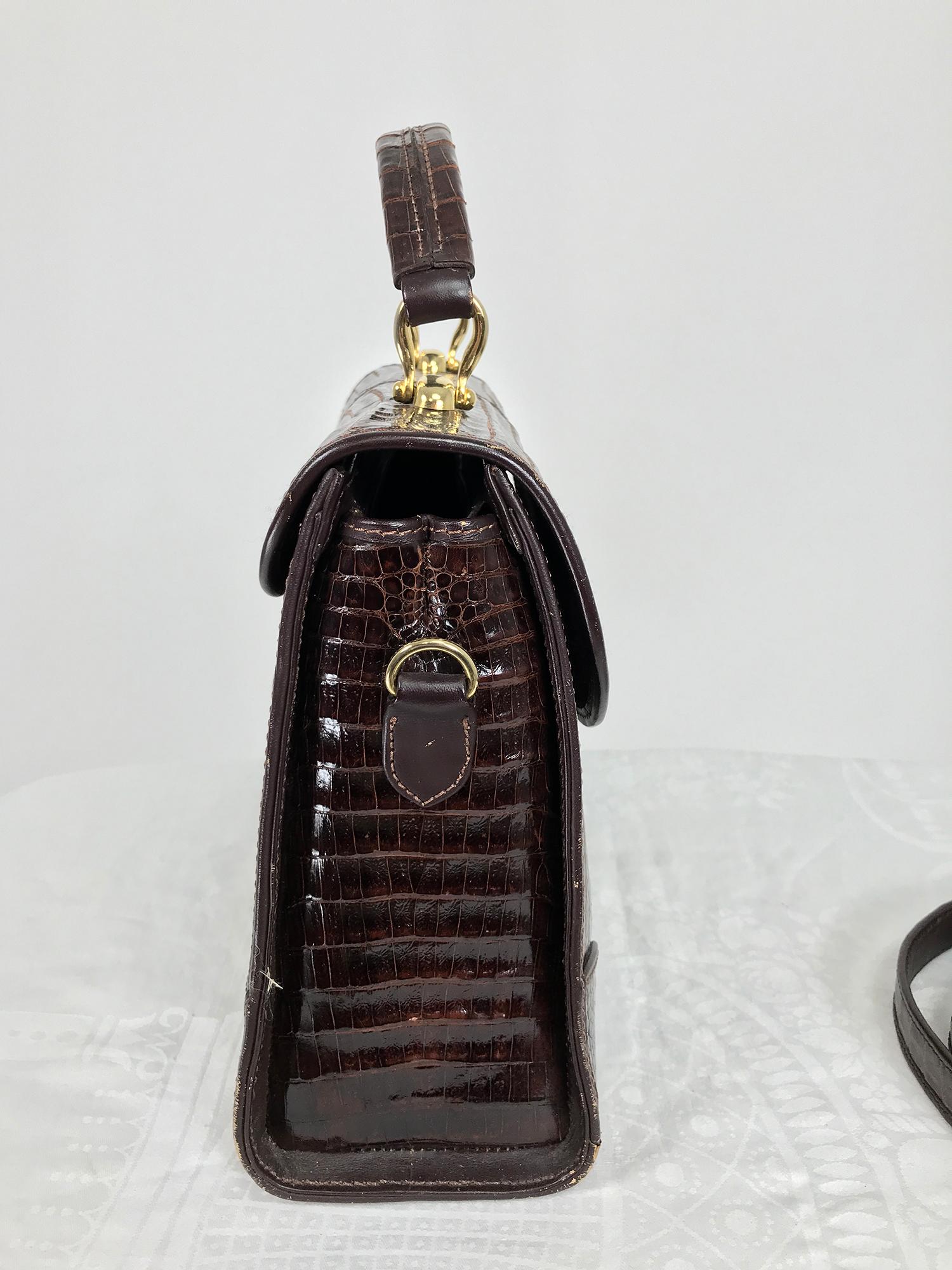 Dark brown caiman top handle satchel with removable shoulder strap. This beautiful bag has a structured shape, with a flap front and lovely gold hardware, the clasp has a push lock, the keys are missing. 5 protector feet at the base. The bag has a