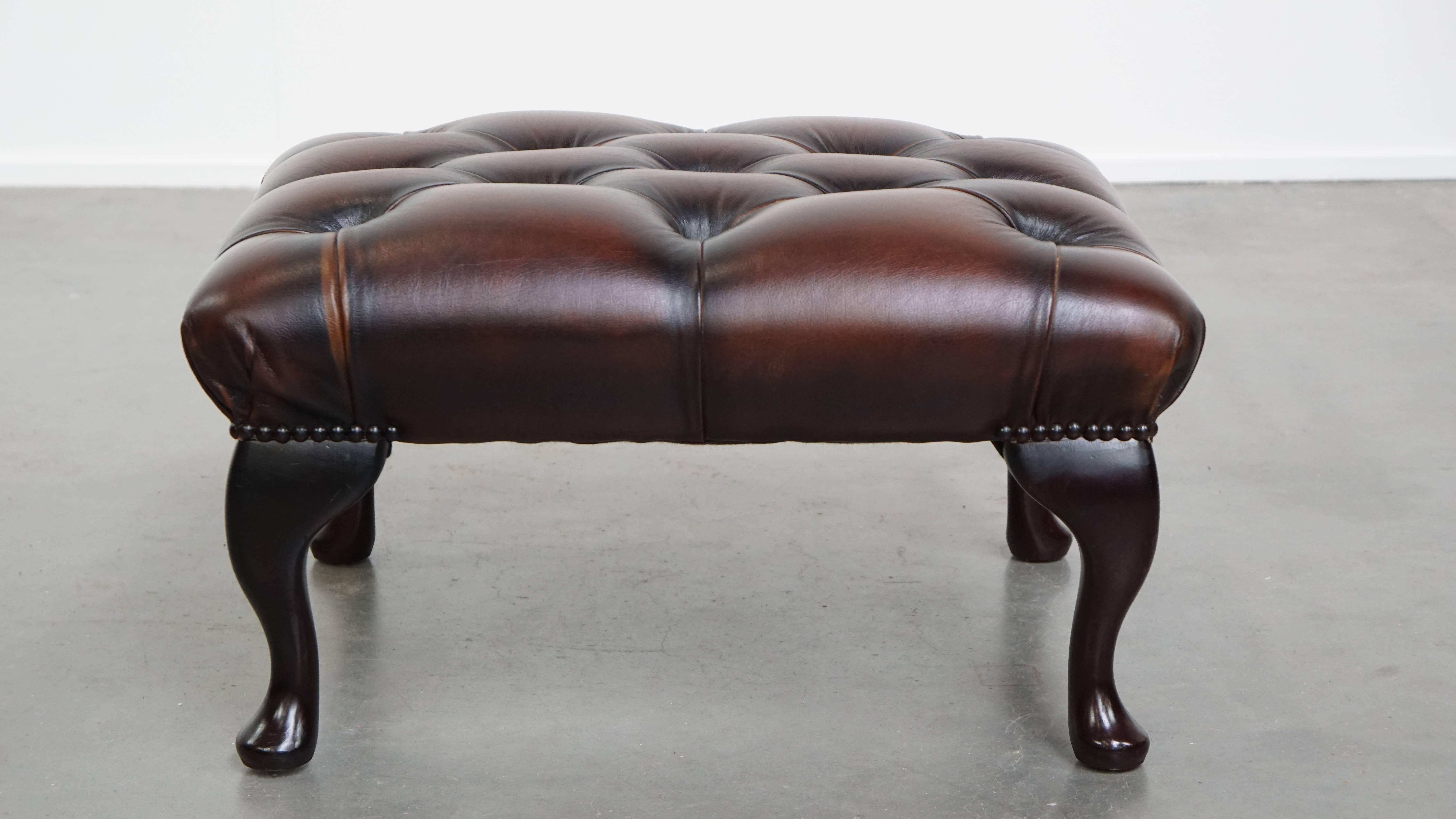 Angeboten wird ein eleganter dunkelbrauner Chesterfield-Ottoman aus Rindsleder. Ein Fußschemel aus Rindsleder, auch Ottomane genannt, verwandelt Ihren ohnehin schon bequemen Sessel in ein wahres Entspannungsparadies. Wenn Sie Ihre Füße auf diesem