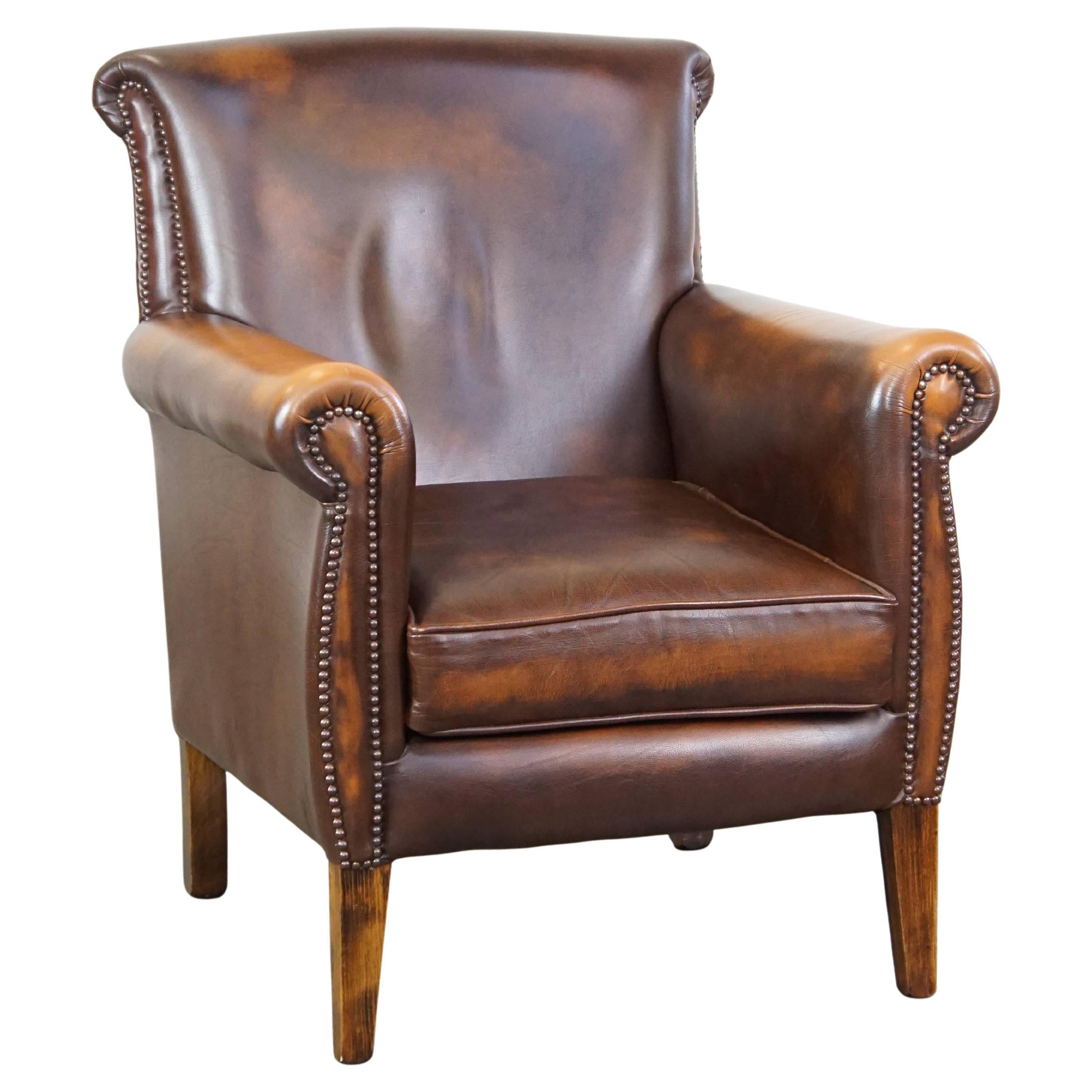 Dark brown cow leather English style armchair with a robust appearance For Sale