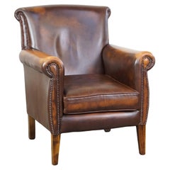 Dark brown cow leather English style armchair with a robust appearance