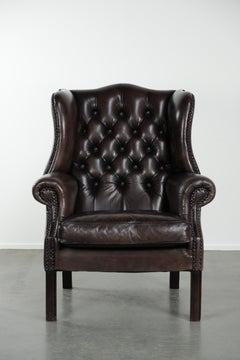 Dark brown cowhide Chesterfield wingback armchair in classic English style