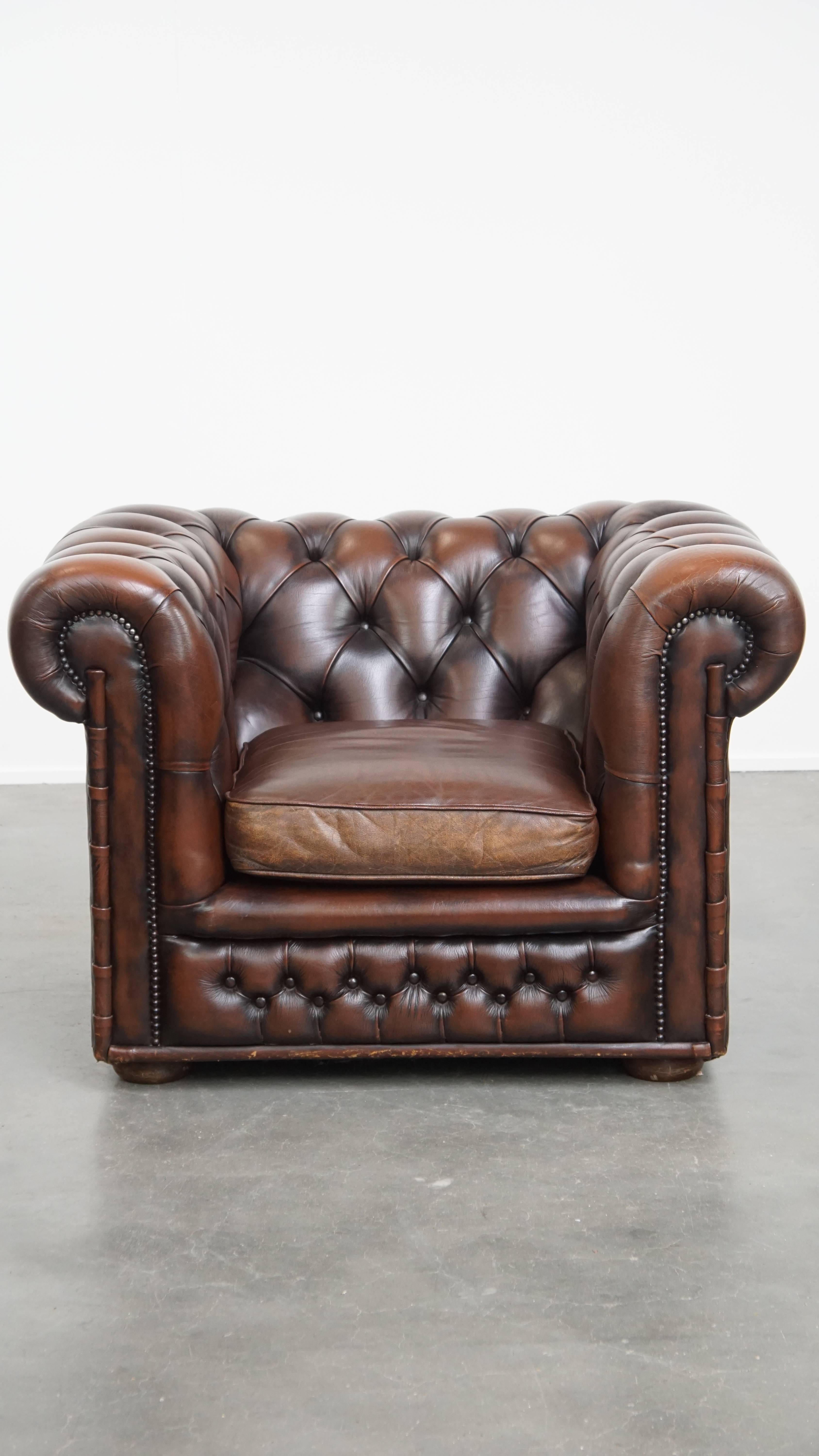 Offered here this classic and luxurious dark brown English cowhide Chesterfield armchair with decorative studs. This stunning English Chesterfield armchair is a true eye-catcher in both classic and modern interiors. It is a characterful and