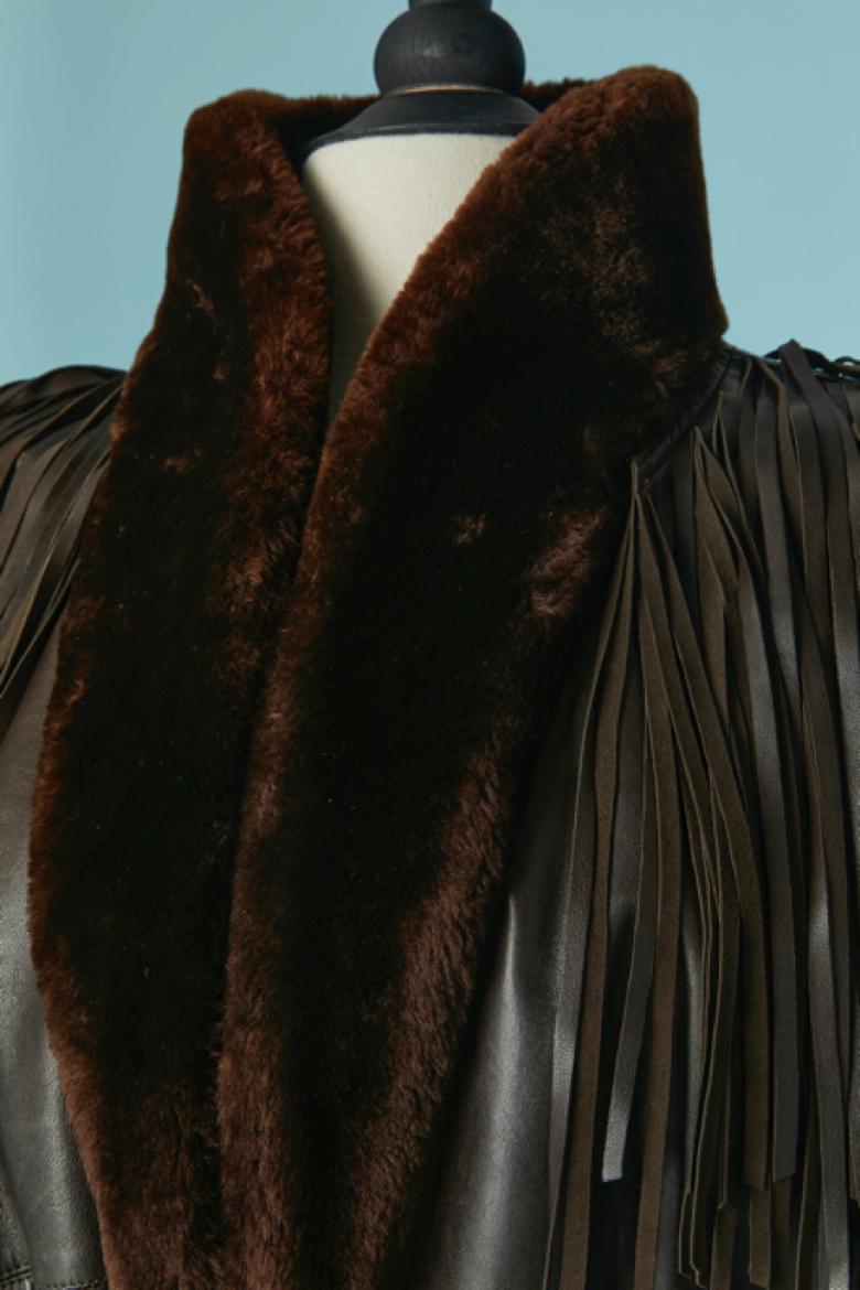 Manteau en fourrure et cuir marron foncé avec ceinture et franges Pad. Pochette sur les deux côtés. Ceinture et passant en cuir surpiqué. 
TAILLE 38 (Fr) M 