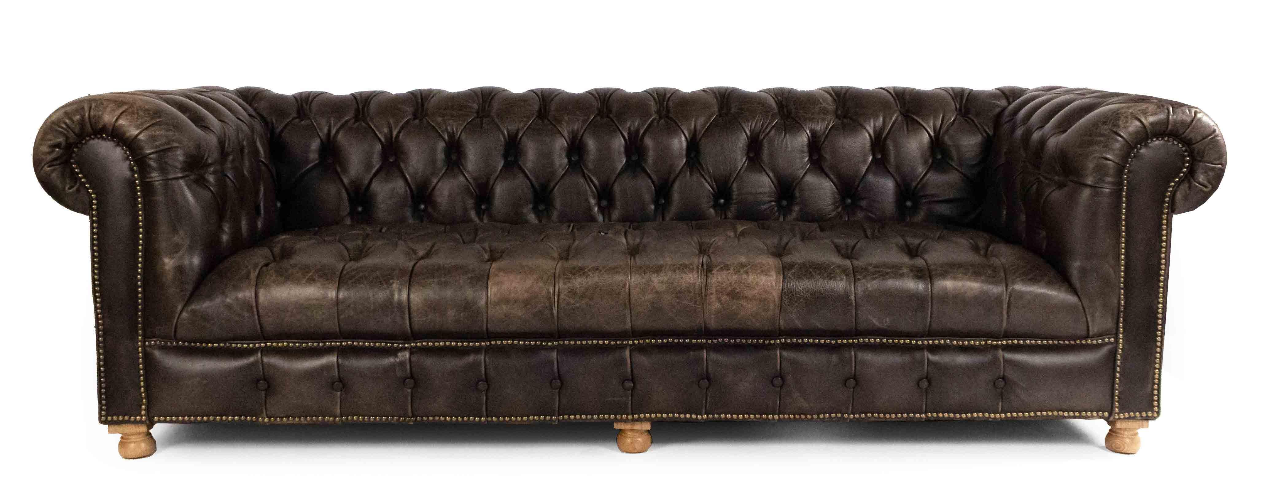 English Victorian style dark brown tufted leather seat and back chesterfield sofa with out-scrolled arms and brass nail head trim resting on wooden brown feet.
  