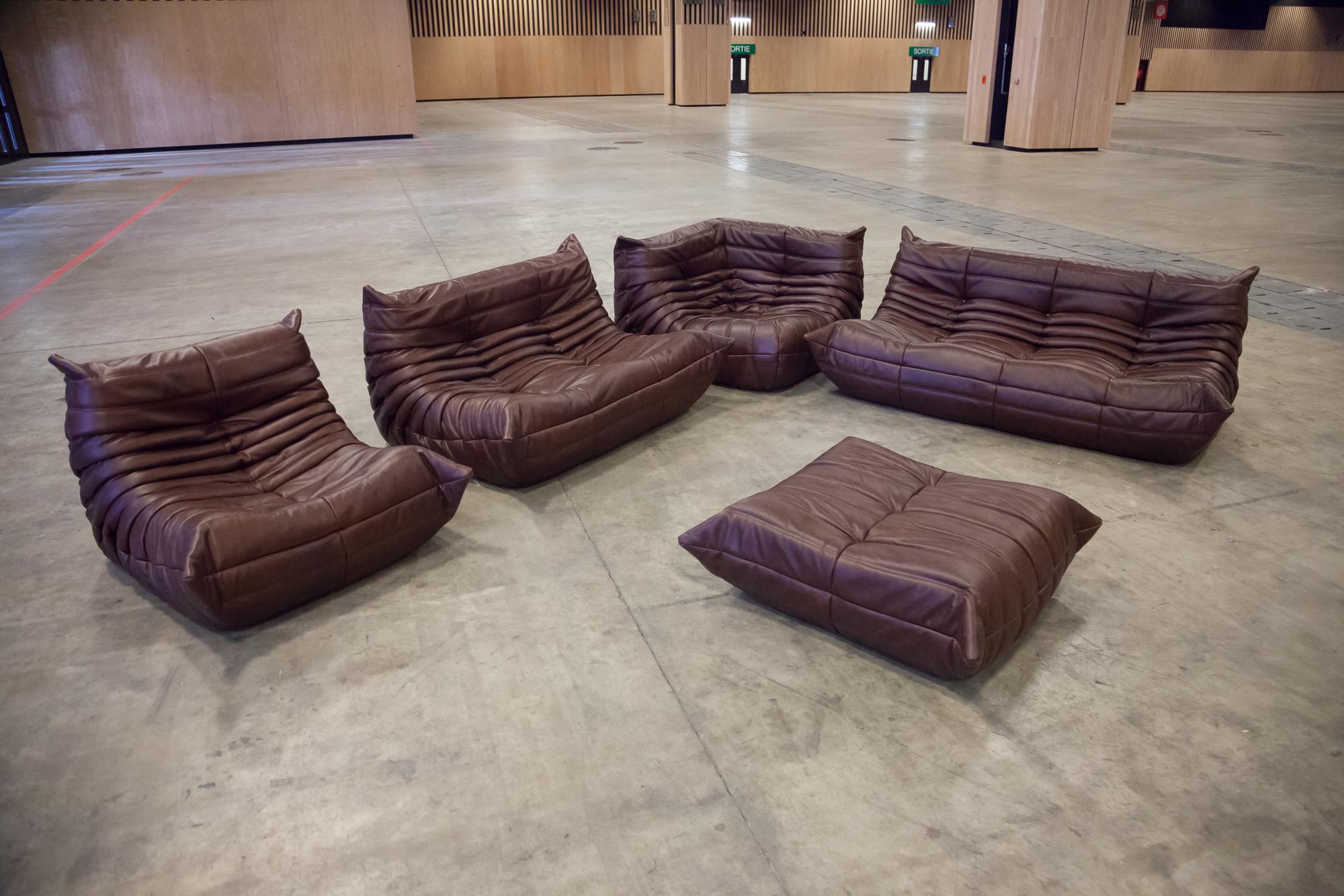 This Togo living room set was designed by Michel Ducaroy in 1973 and was manufactured by Ligne Roset in France. It has been reupholstered in new, genuine dark chocolate brown leather and is made up of the following pieces, each with the original
