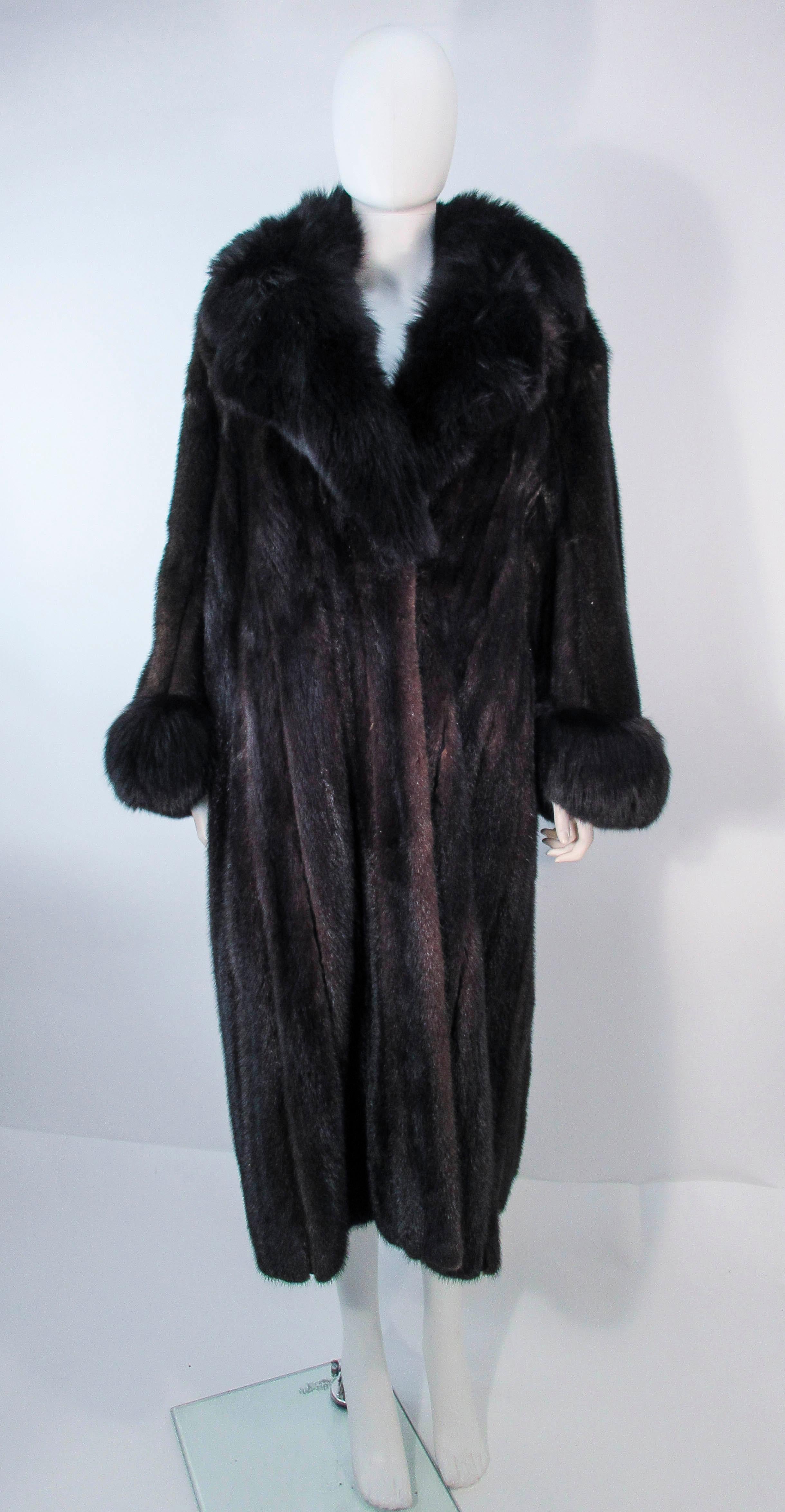 This coat is composed of a dark brown mink, and features fox fur cuffs with a fox fur collar. There are front closures. In excellent vintage condition, some signs of wear due to age. Please feel free to ask us any additional questions you may have.