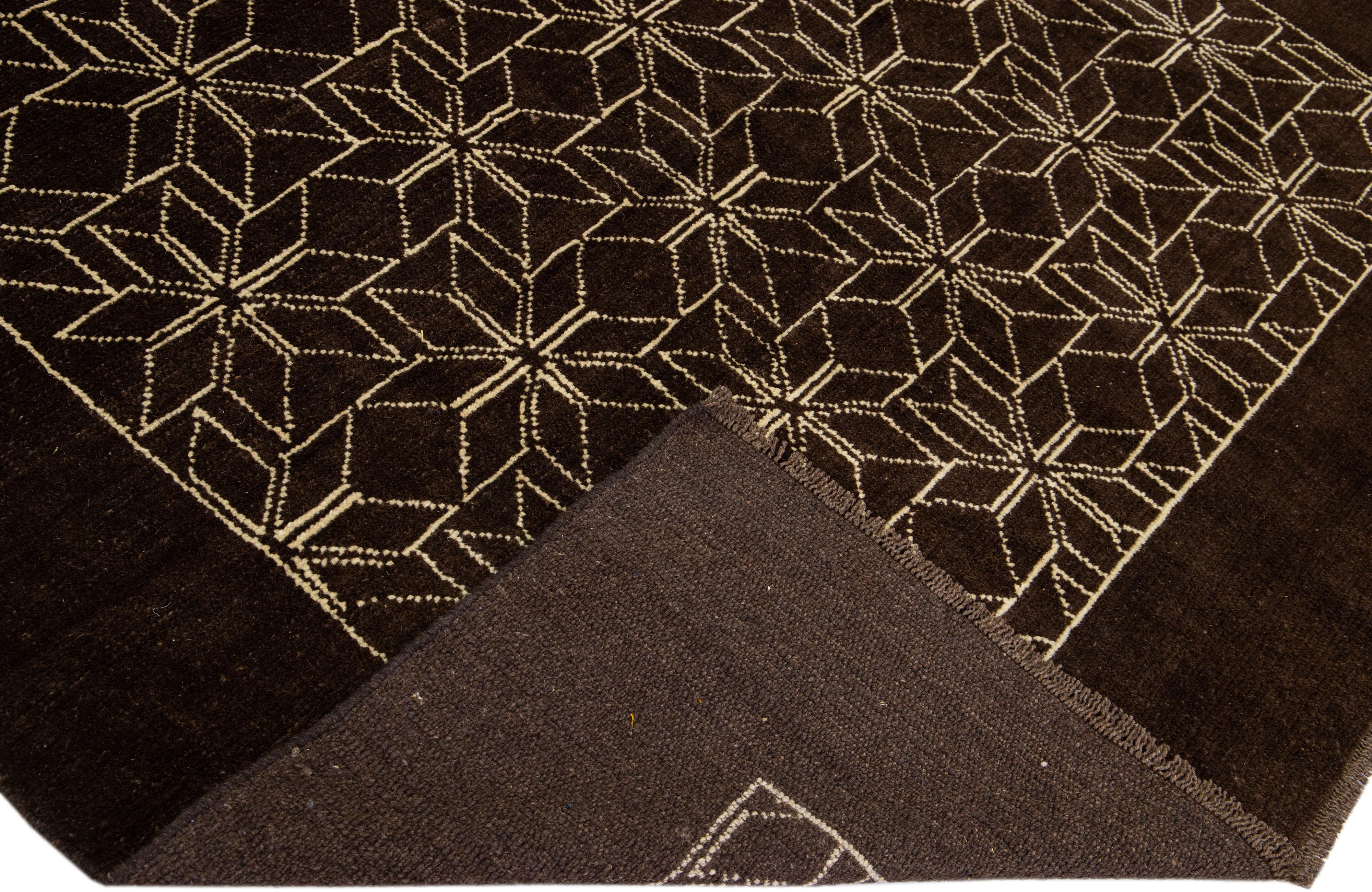 This Beautiful Moroccan-style handmade wool rug makes part of our Northwest collection and features a dark brown color field and beige accents in a gorgeous geometric tribal design.

This rug measures: 7' x 8'11