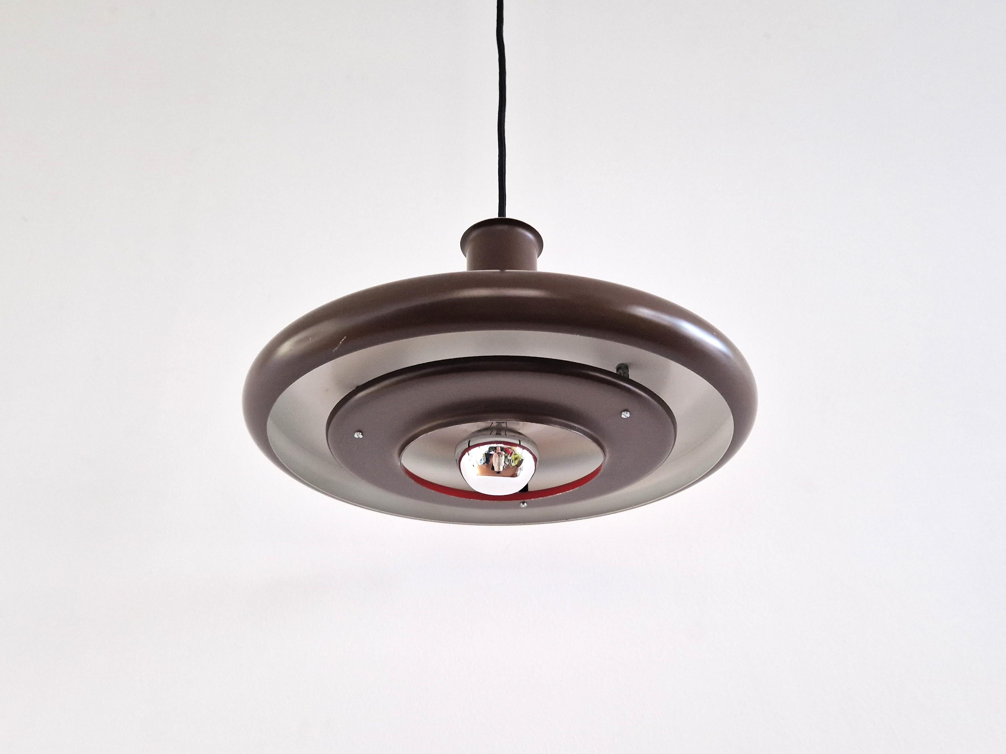 The 'Optima' pendant lamp was designed in 1972 by Hans Due for Fog & Mørup in Denmark. This particular size of ø35 cm appeared towards the end of the 1970's. The lamp is made of brown painted metal. It has a large circular outer shade with a