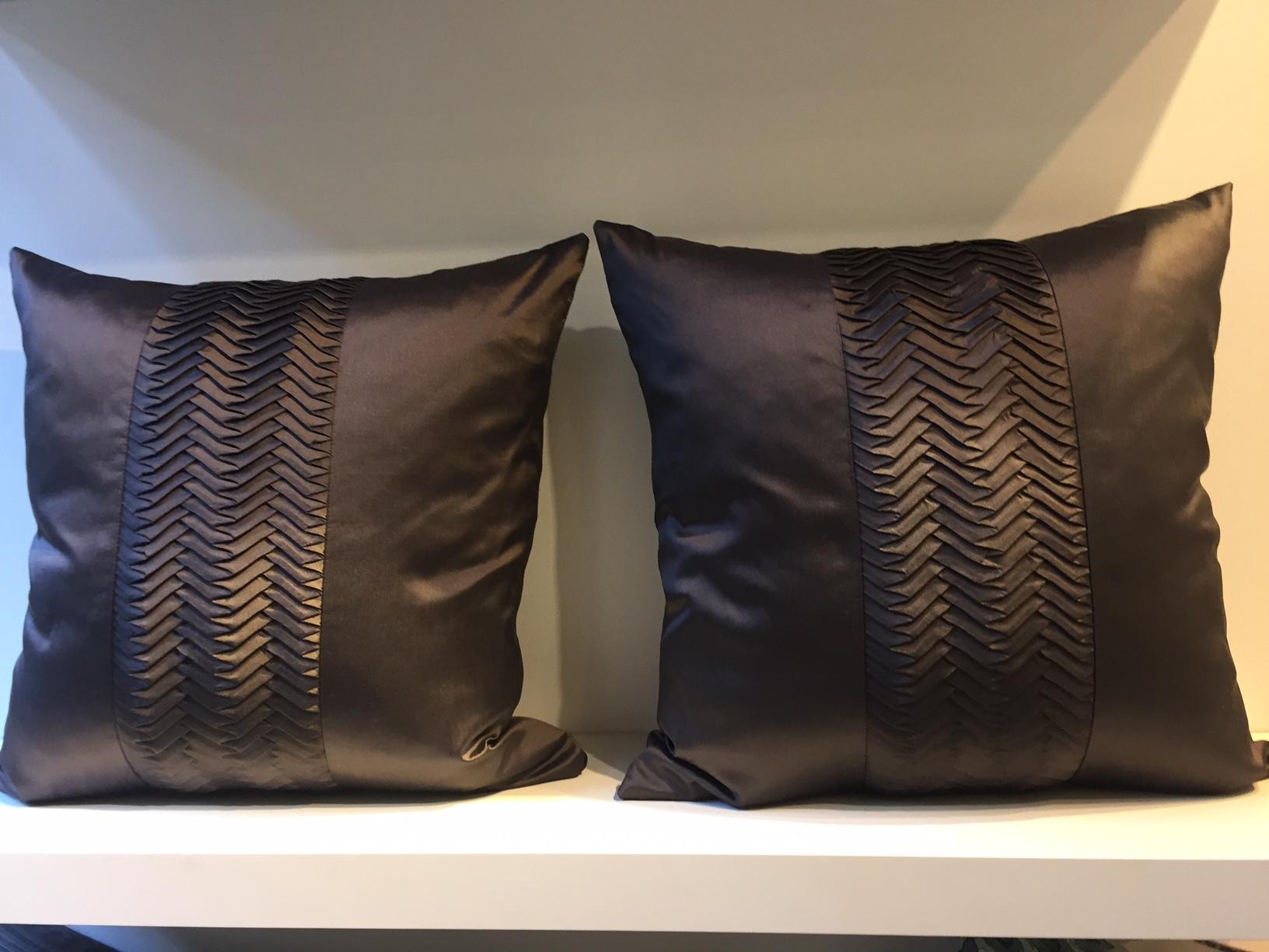 One pair of silk cushions color dark brown with pleated band detail on the front panel, front and back panel in silk taffeta hand woven, band detail silk taffeta embossed by steam pleating, back panel plain silk, cushion size 50 x 50cm, concealed