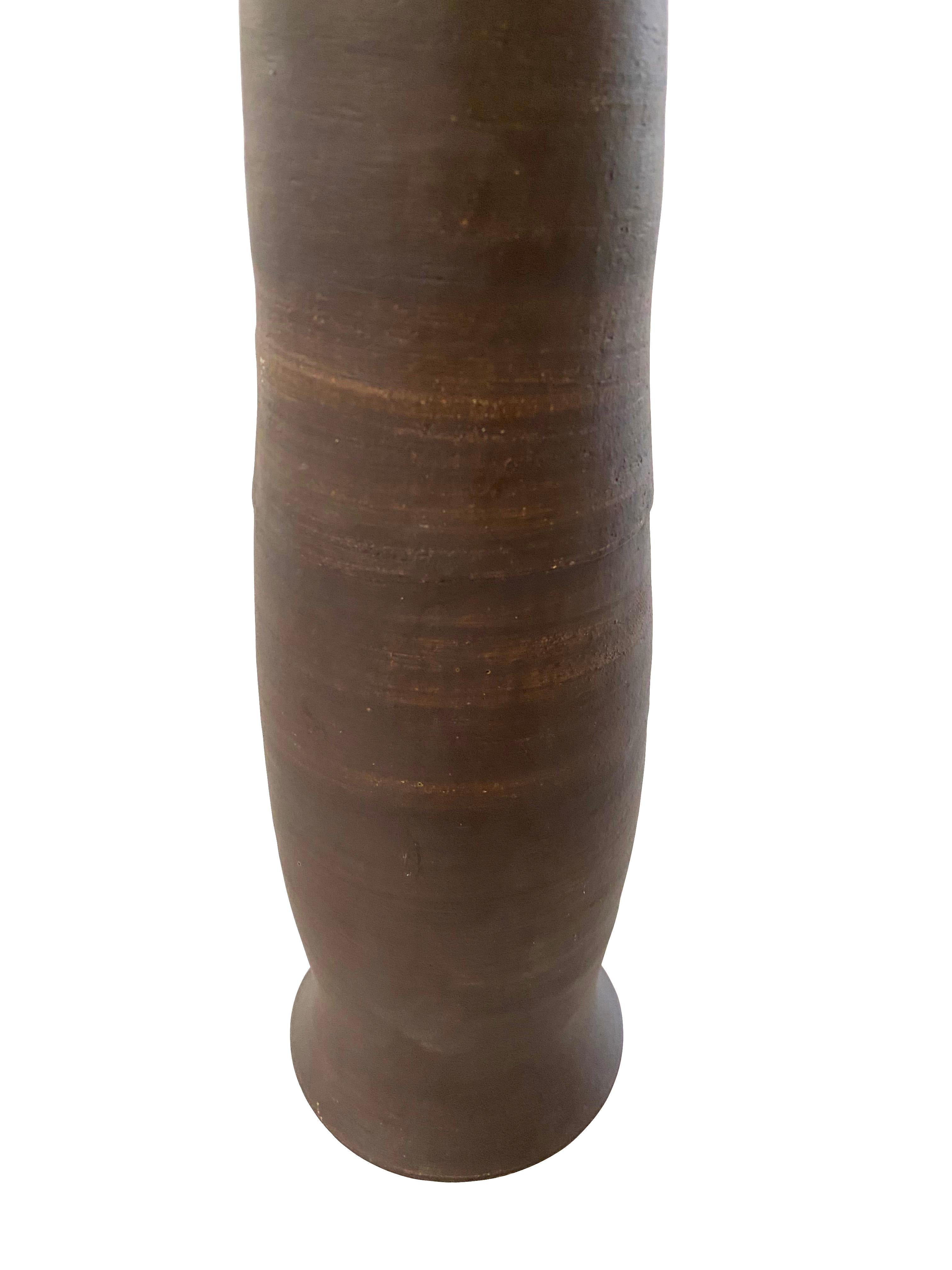 Tall thin chocolate brown textured stoneware vase.
Matte finish
Can hold water
Veteran photographer Sandi Fellman's ceramic vessels are an exploration of a new medium. The forms, palettes, and sensuality of her photos can be found within each