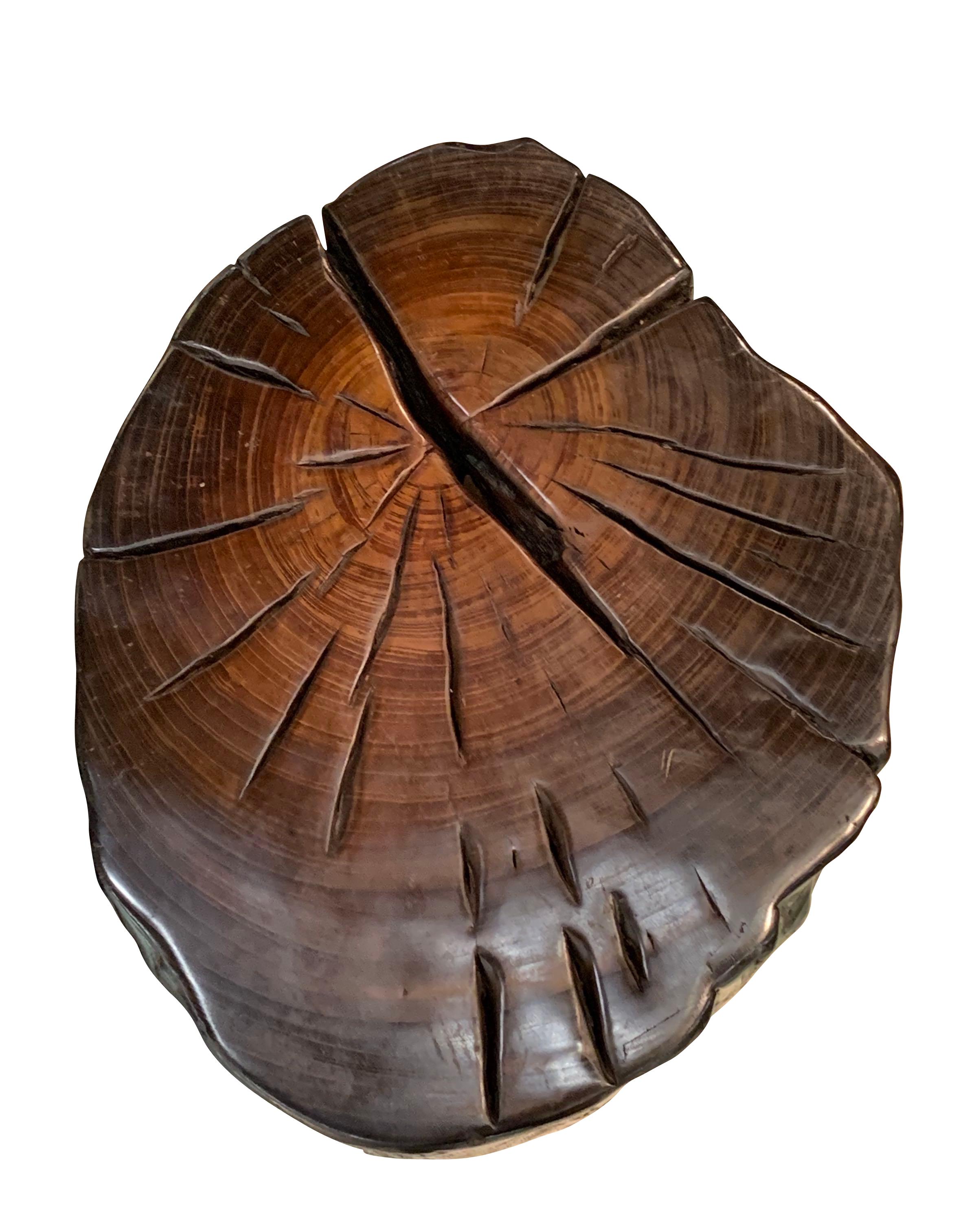 This Indonesian Walang tree side table is dark brown in color, has textured sides and a flat top.
The top has lighter brown shading at the center giving it an ombre effect and defines the rings of the tree.
It has a beautiful polished finish and