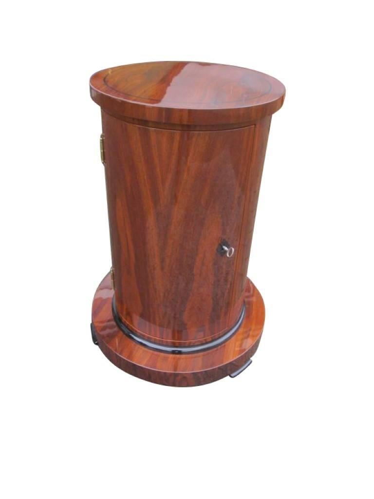 A drum cabinet in the Biedermeier style made of walnut wood which is a remake after old template. A beautiful wood color throughout the whole piece with black accents at the foot and the plate. The typical walnut wood veneer shines with a