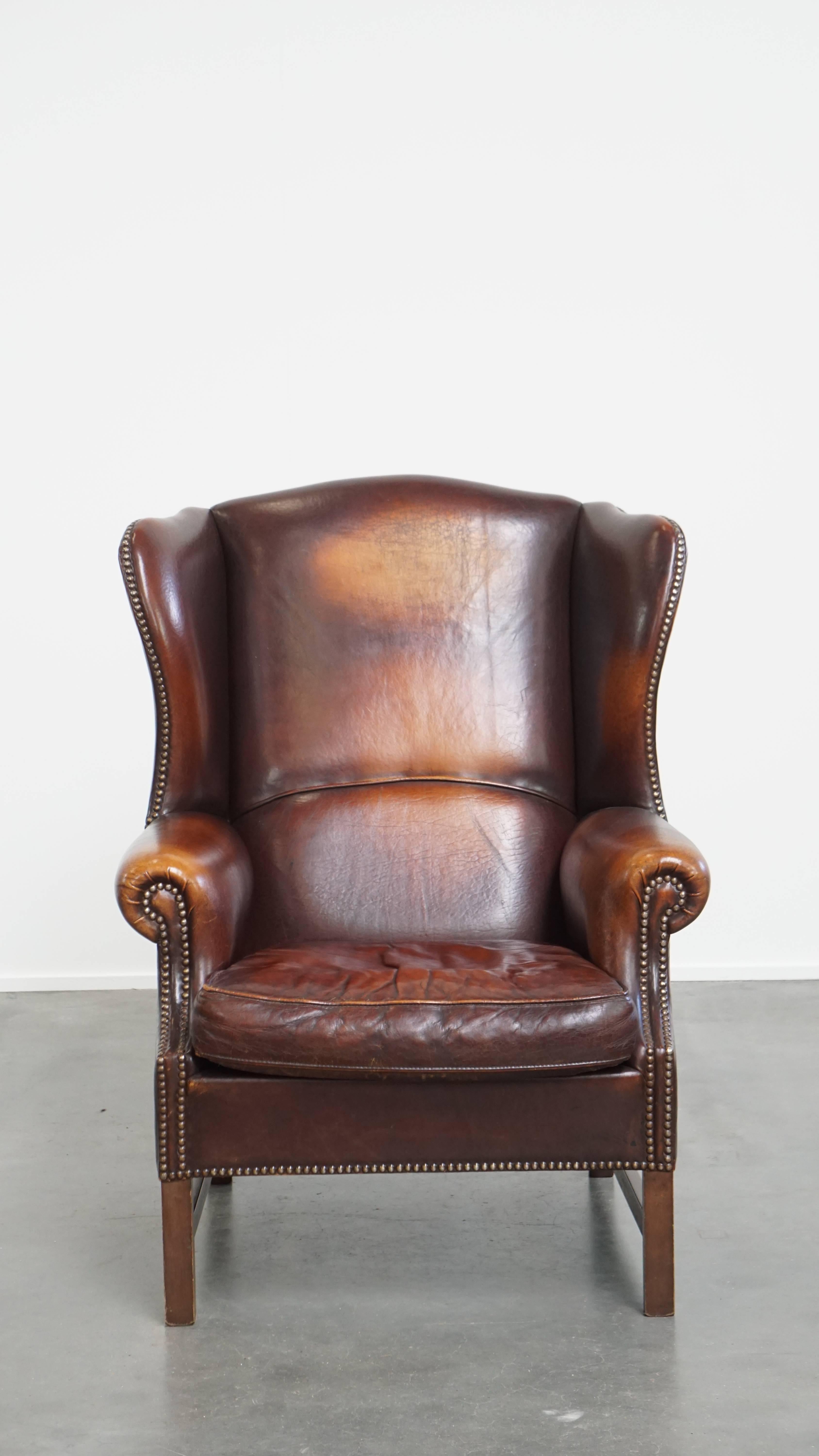 Qui viene offerta una lussuosa, classica e confortevole poltrona a dondolo in pelle di pecora in stile inglese, piena di carattere e caratterizzata da una splendida patina. Questa poltrona in pelle di pecora abbraccia lo stile tradizionale inglese