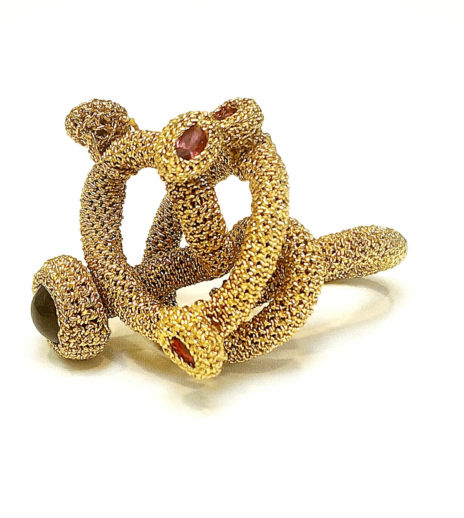 This is a very unique ring. I call it my galaxy ring. It is crochet around a metal wire which I then shaped into a spiral. I then added red crystals to enhance the movement of this beauty. The thread is a light gold smooth passing thread.  This ring