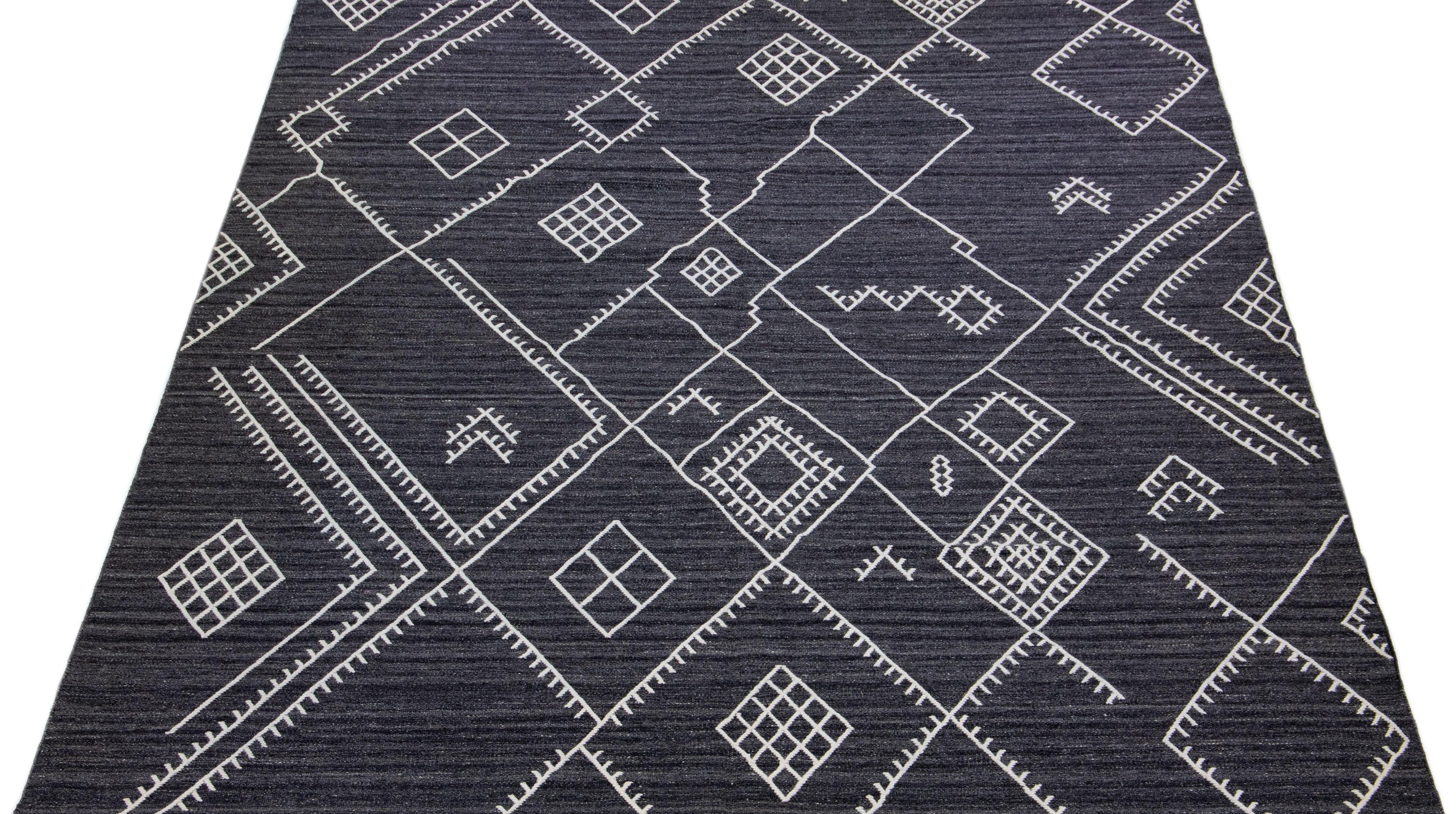 Beautiful kilim handmade wool rug with a gray-charcoal field. This custom modern flatweave rug of our Nantucket collection has white accents and a gorgeous, all-over geometric coastal design.

This rug measures: 10' x 13'9
