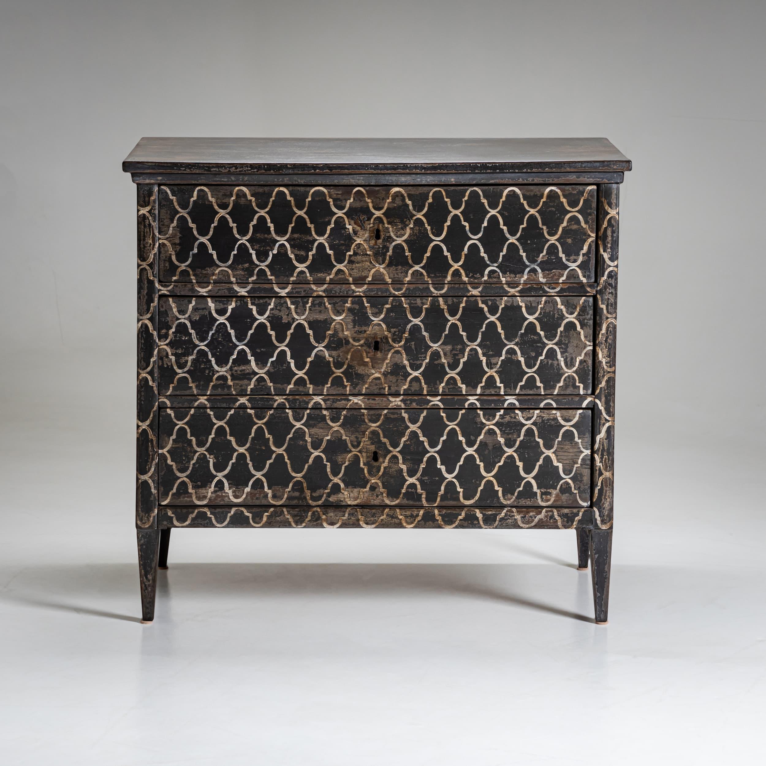 Elegant Biedermeier commode featuring three drawers and a new hand-painted dark gray surface. The geometric pattern in white tones gives the piece a distinctive appearance. Its tapered legs emphasize the simple yet sophisticated design typical of