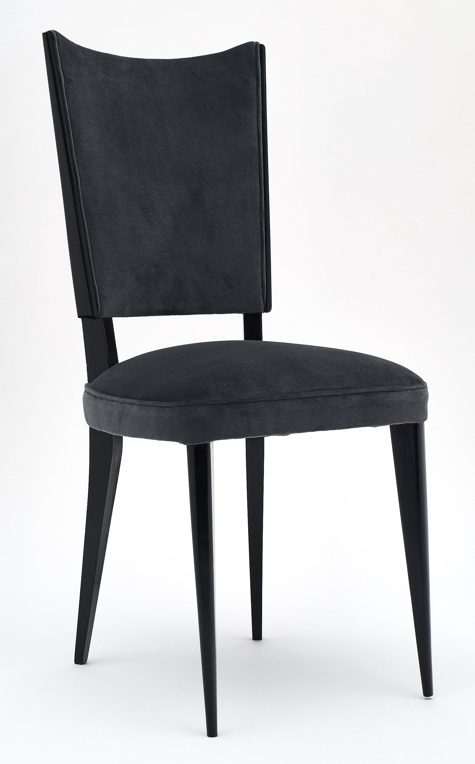 A set of French midcentury dark gray velvet dining chairs with ebonized beech wood frames finished in a lustrous French polish. We loved the comfort and the perfect lines of these strong chairs. They have been newly upholstered.
