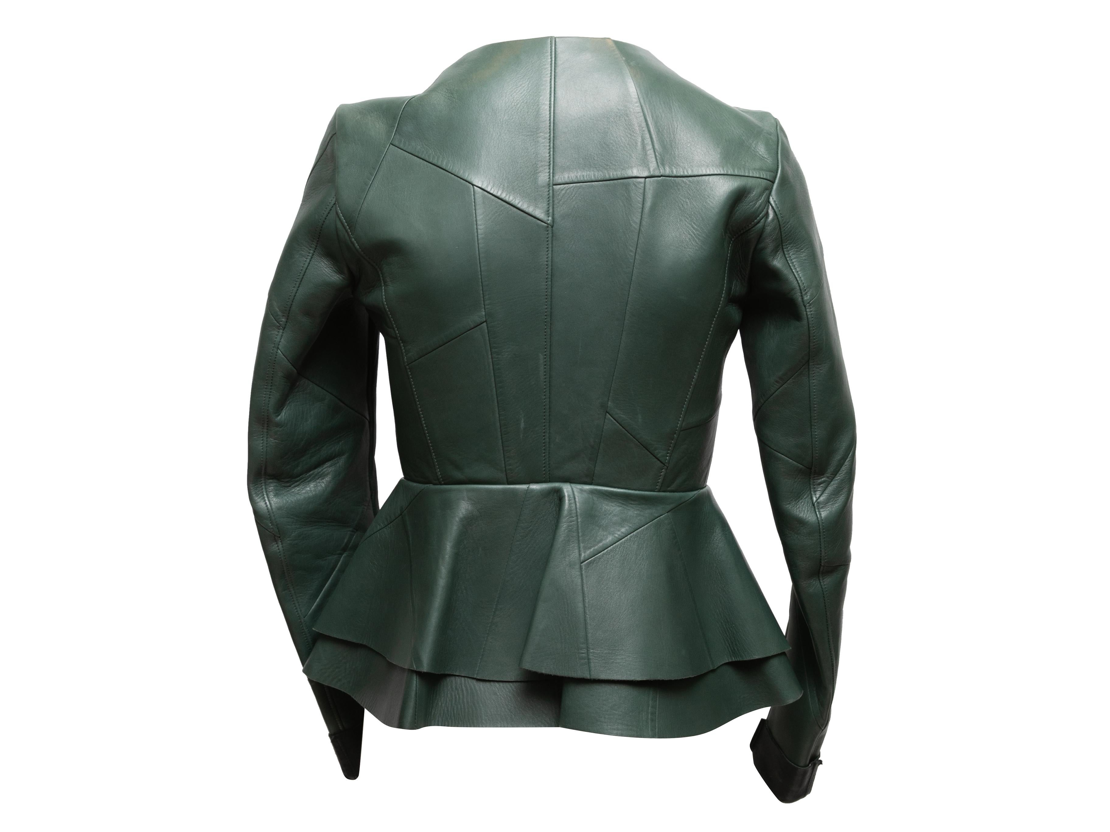 Dark green leather peplum jacket by Celine. Crew neck. Zip closure at center front. 31