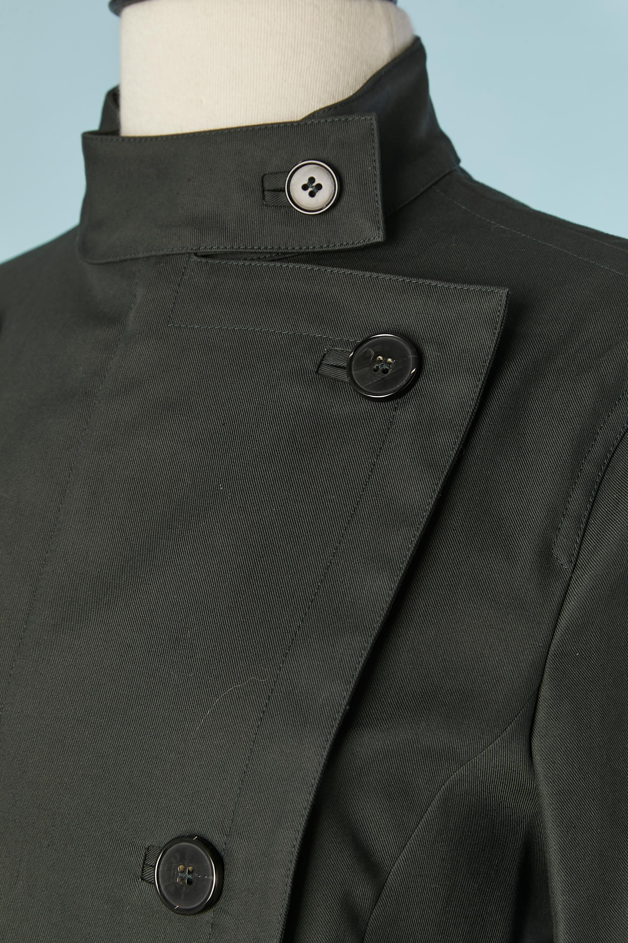 Giacca doppiopetto in cotone verde scuro. Chiusura con cerniera nascosta sul centro della fronte e chiusura con bottone e asola sulla parte superiore. Tasca su entrambi i lati. Profili in gros-grain bianchi all'interno. 
TAGLIA 36 (Fr) S 