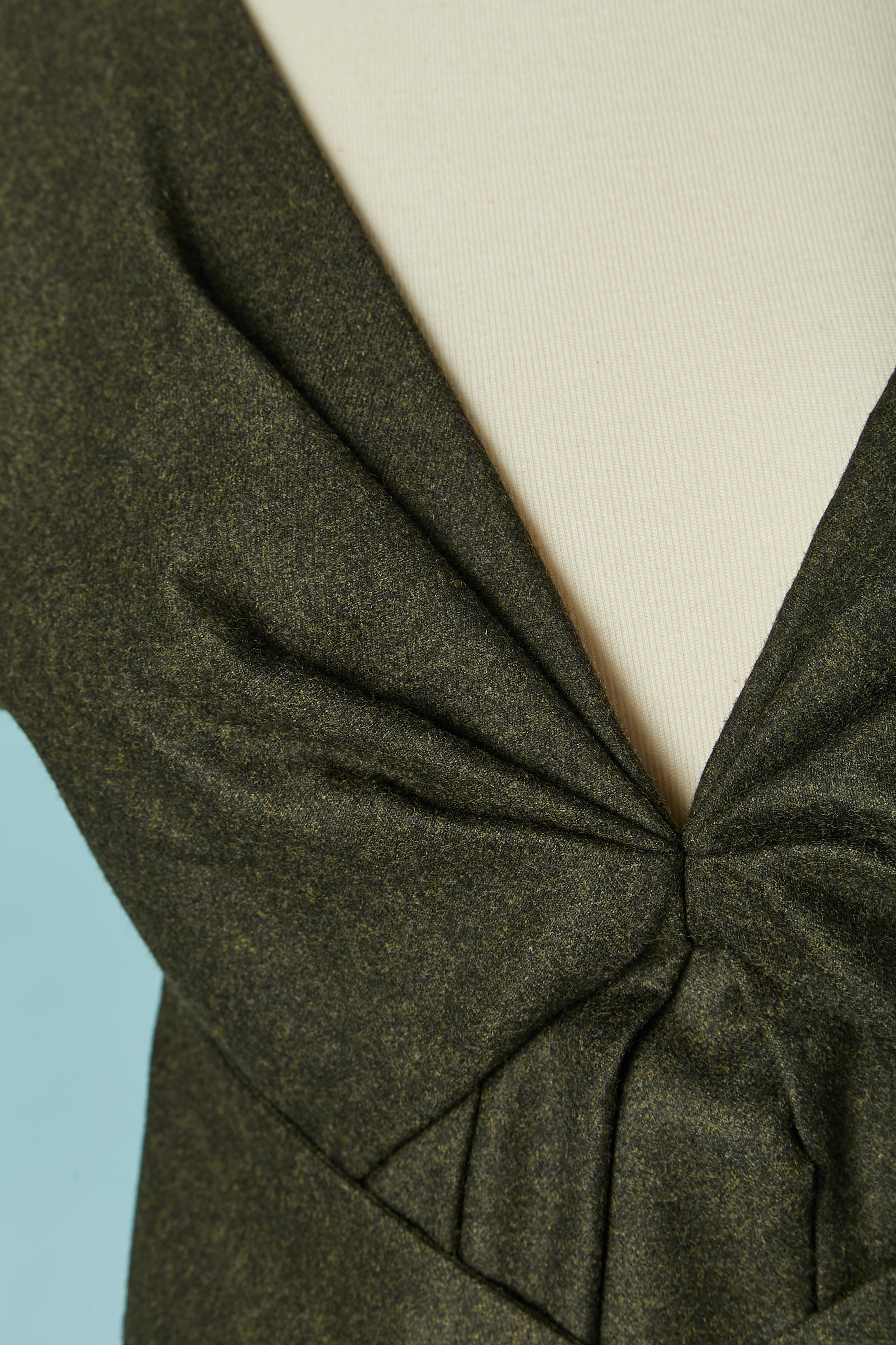 Flanelle vert foncé avec demi-courroie nouée à la taille. Composition du tissu principal : 90% laine, 10% cachemire. Doublure : 52% acétate, 48% rayonne. 
Fermeture à glissière et crochet au milieu du dos. Manches raglan. 
TAILLE 38 (It) 34 (Fr) 4