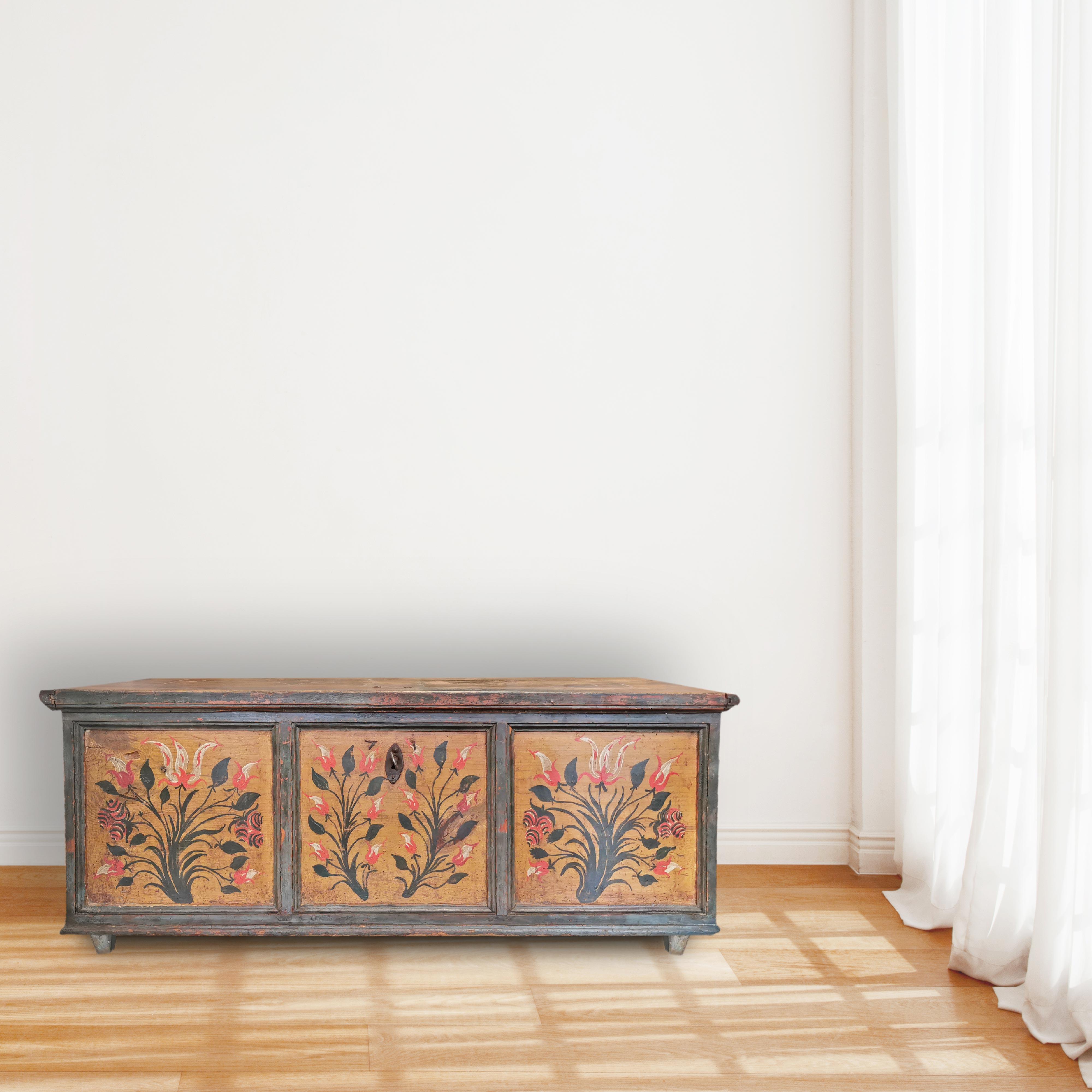 Floral Green Painted Blanket Chest
H.48 cm – W.118 cm – D.57 cm
Painted Tyrolean chest, dark green/teal blue.
On the front, three large framed backgrounds enclose floral decorations on a natural wood background.
On the sides there are geometric