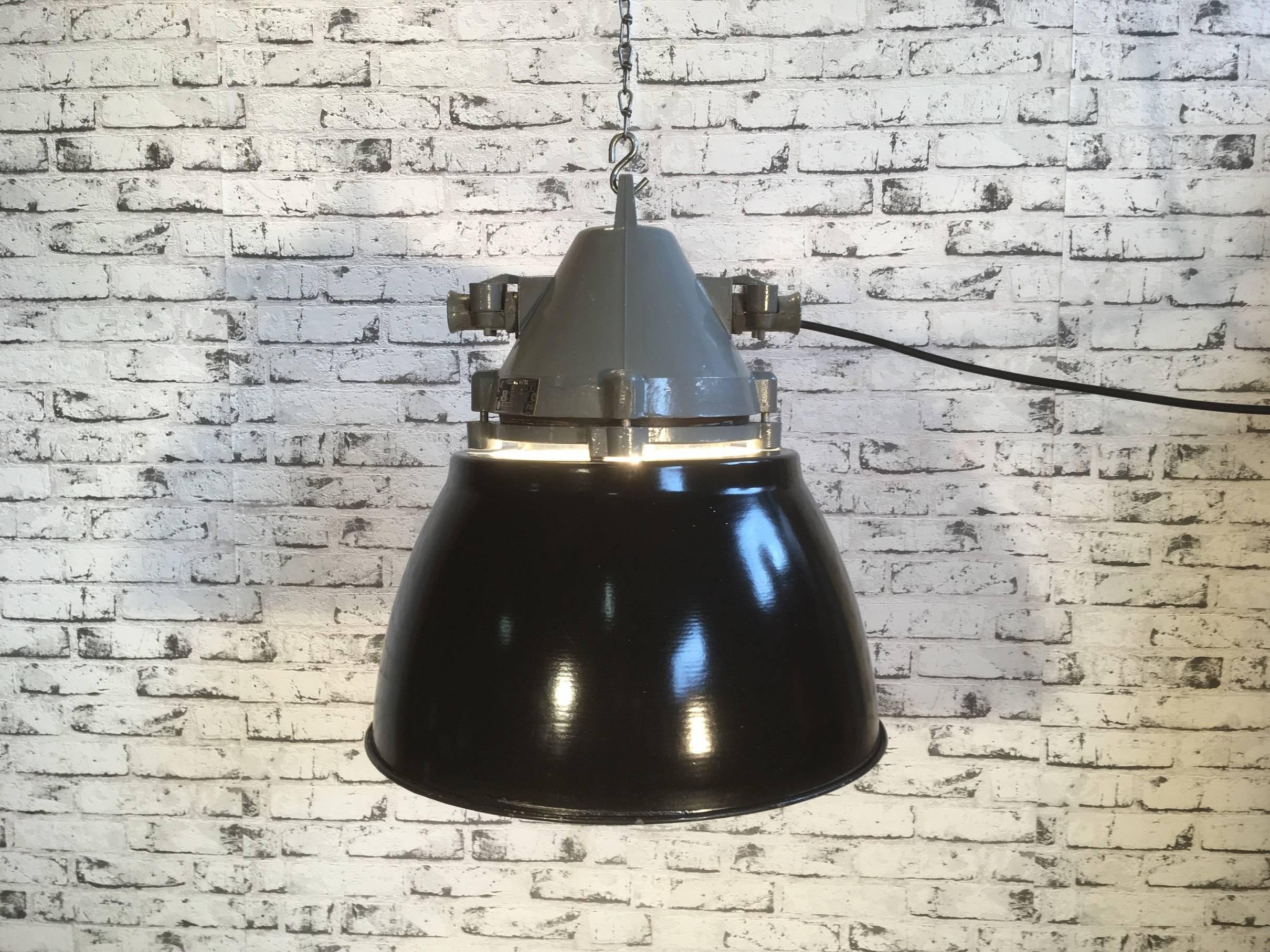 Dark grey  industrial lamp with massive protective glass bulb. Grey cast aluminium body, clear glass. Black enameled shade with white interior. Porcelain socket for E27 bulbs. Newly wired. Weight: 6.0 kg.