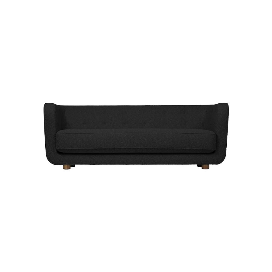 Dark grey and smoked oak Hallingdal Vilhelm sofa by Lassen
Dimensions: W 217 x D 88 x H 80 cm 
Materials: textile, oak.

Vilhelm is a beautiful padded three-seater sofa designed by Flemming Lassen in 1935. A sofa must be able to function in