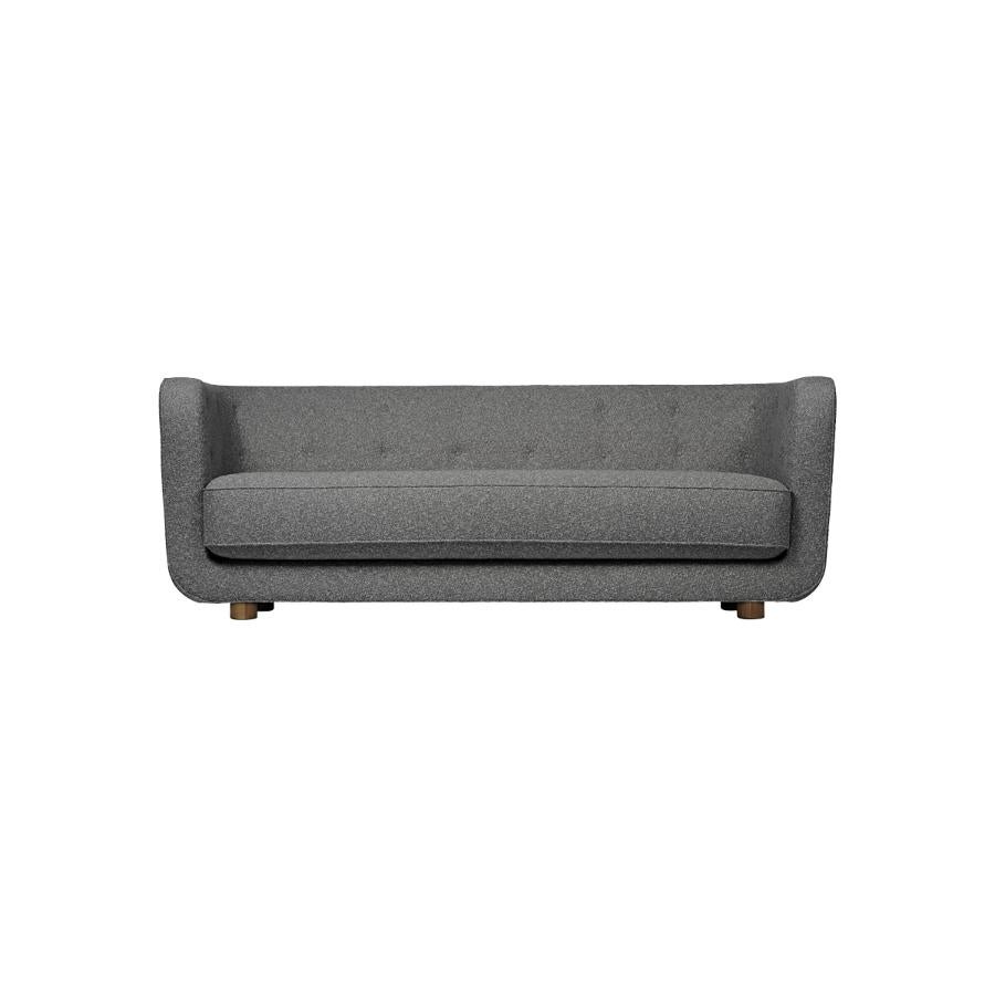 Dark grey and smoked oak Sahco Nara Vilhelm Sofa by Lassen
Dimensions: W 217 x D 88 x H 80 cm 
Materials: textile, oak.

Vilhelm is a beautiful padded three-seater sofa designed by Flemming Lassen in 1935. A sofa must be able to function in