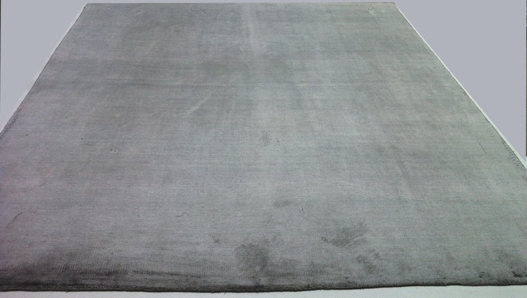 Soft-to-the-touch viscose area rug in dark grey. Handmade in India. 'Dark' and 'light' sides (shown here) when viewed from different angles.