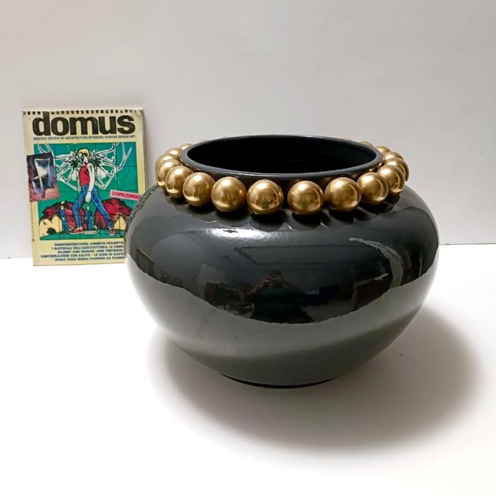 Made in Italy, anni '50.
Questo elegante vaso/centrotavola è realizzato in ceramica laccata grigio scuro/verde scuro e perle dorate.
La scritta è riportata sul fondo, ma purtroppo è difficile da decifrare. 
Si tratta di un pezzo vintage, quindi