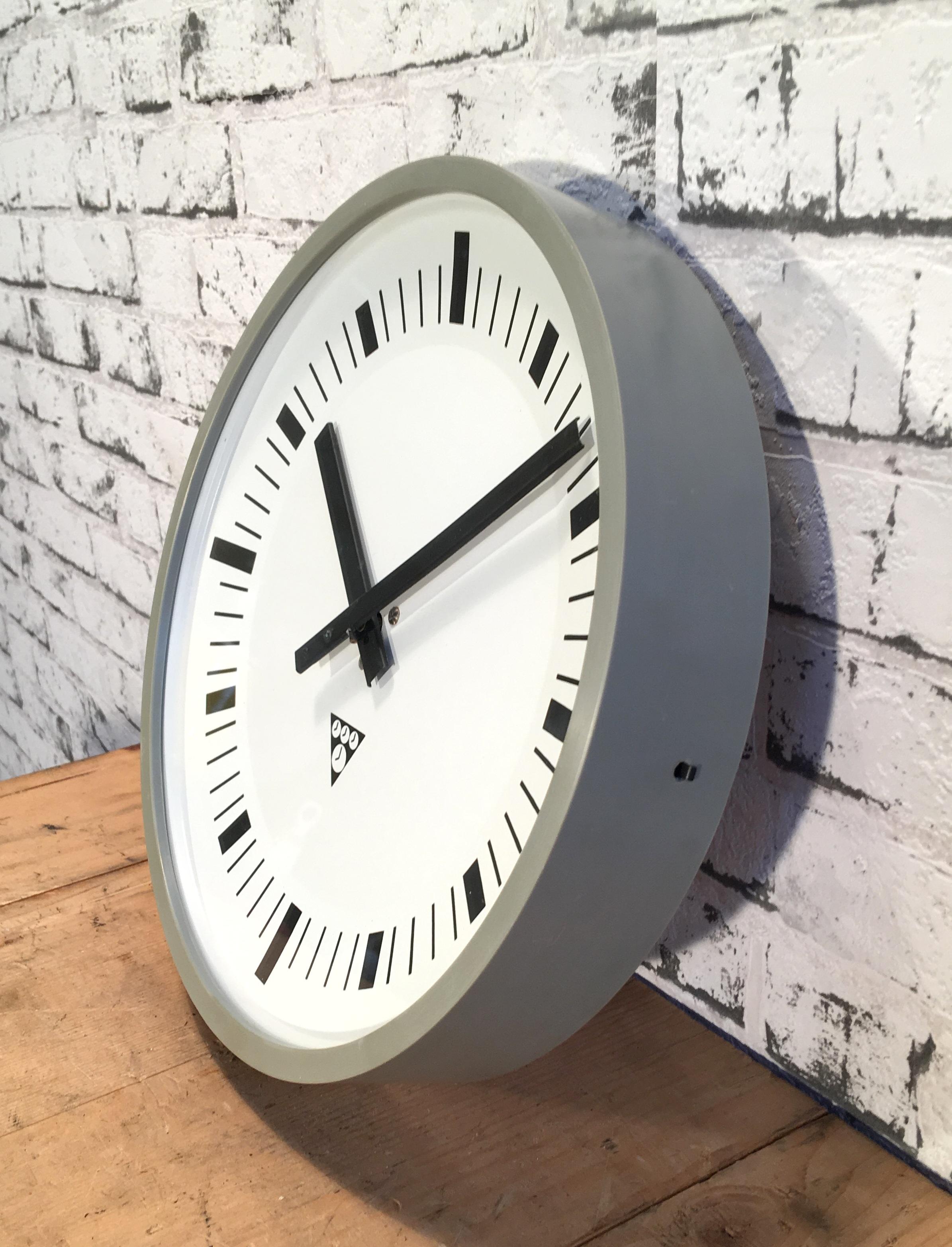 This wall clock was produced by Pragotron in former Czechoslovakia during the 1970s. The piece features a dark grey Bakelite frame and clear glass cover. The piece has been converted into a battery-powered clockwork and requires only one AA-battery.