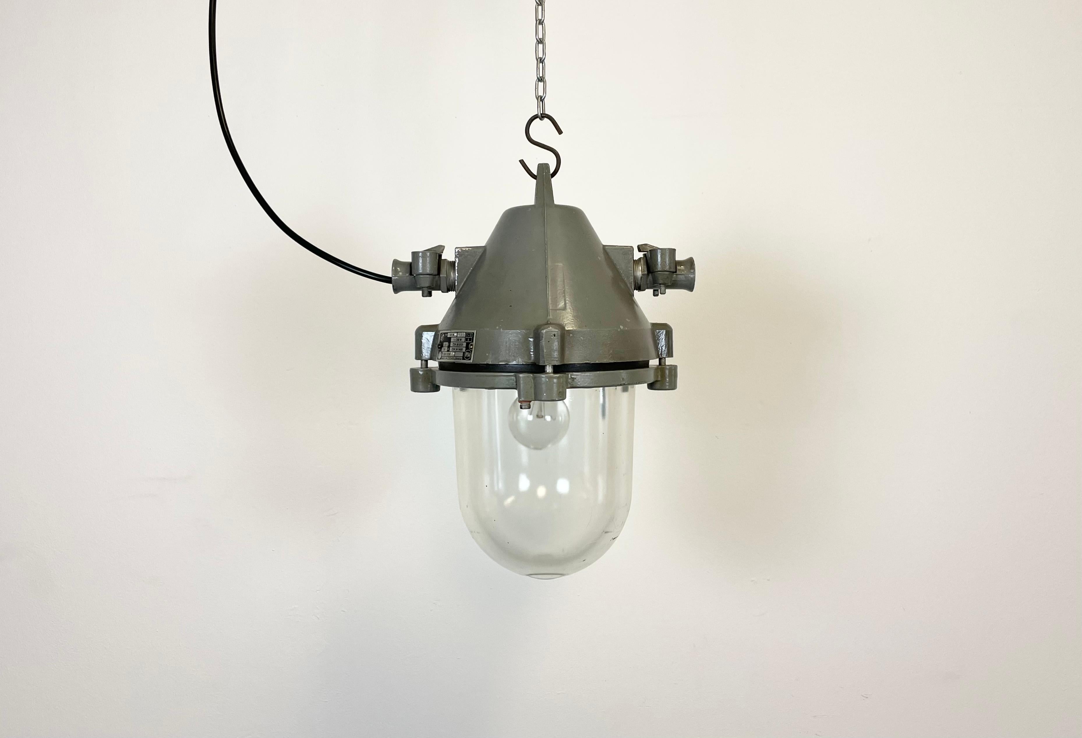 Dark grey industrial explosion proof light with massive protective glass bulb. Made in former Czechoslovakia by Elektrosvit during the 1970s.It features a cast aluminium body and a clear glass cover. Original porcelain socket requires standard E27/