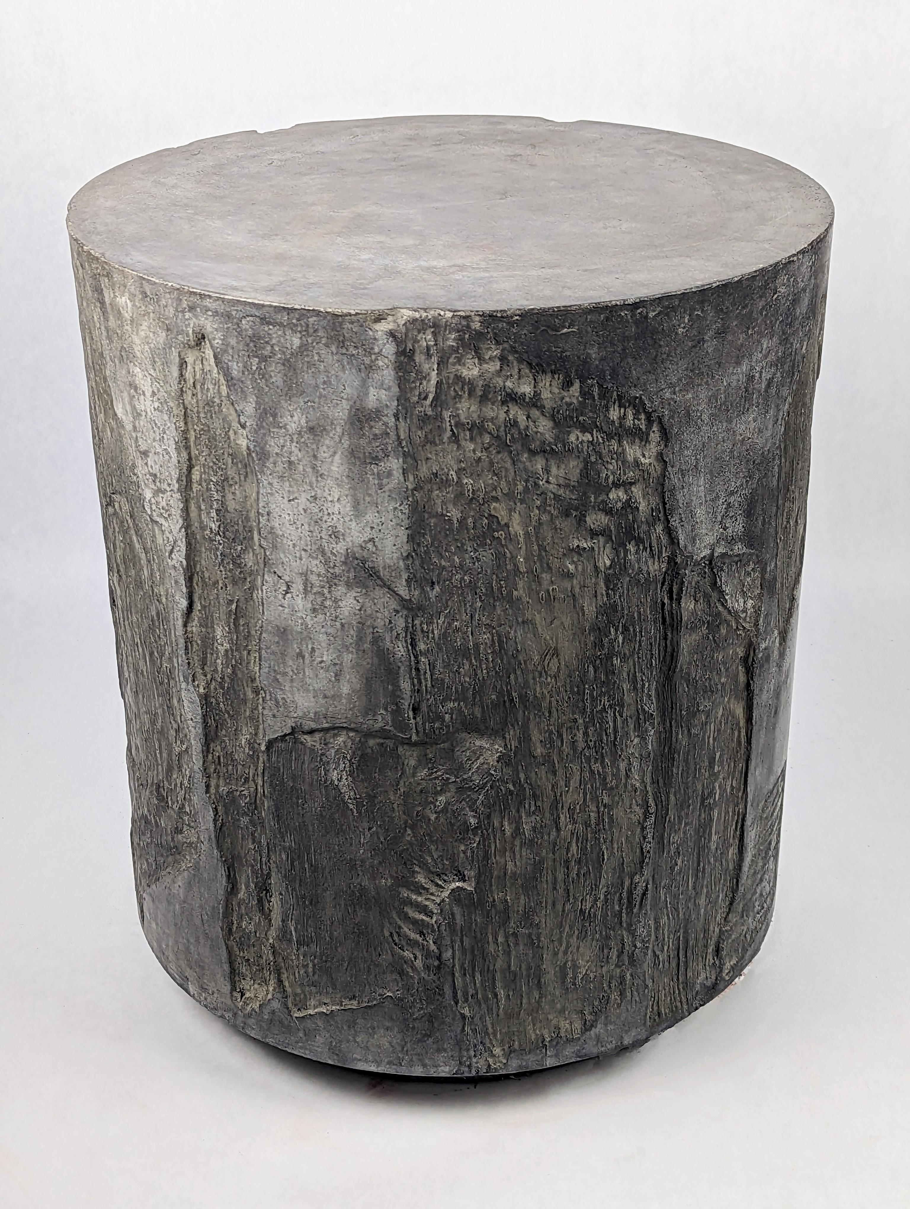 Dark gray, artistic concrete side table or stool with intricate, rock-like patterns on the sides from impressions of paper bark, a tree from Australia. This unique and rustic work would fare well in a modern alcove or a slightly unkempt garden