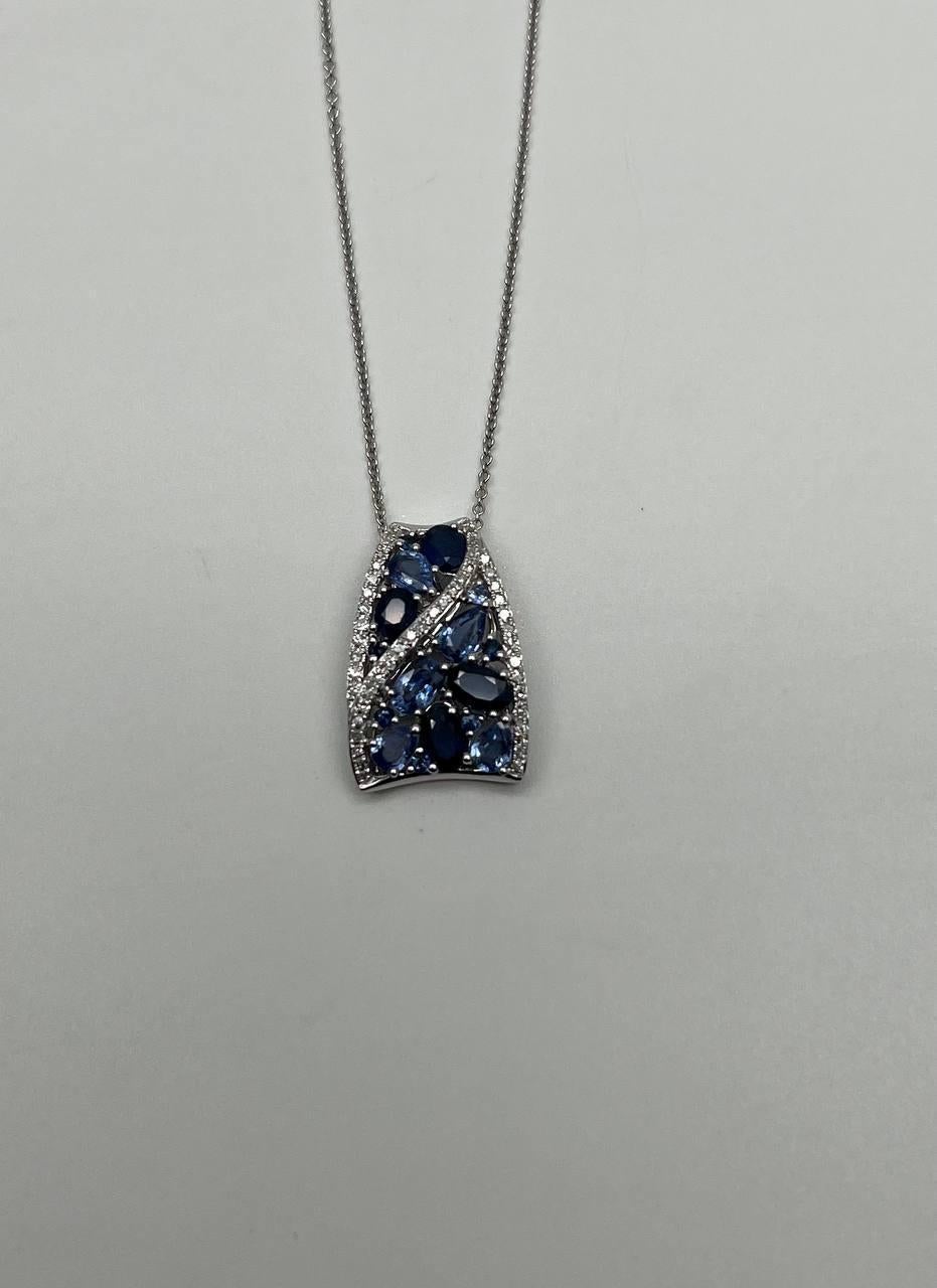 Prova la raffinata maestria di questa collana con ciondolo... Questo pezzo presenta un ciondolo ornato da zaffiri blu intenso, elegantemente incastonati in una cornice d'oro bianco. Il design presenta una disposizione armoniosa di pietre,