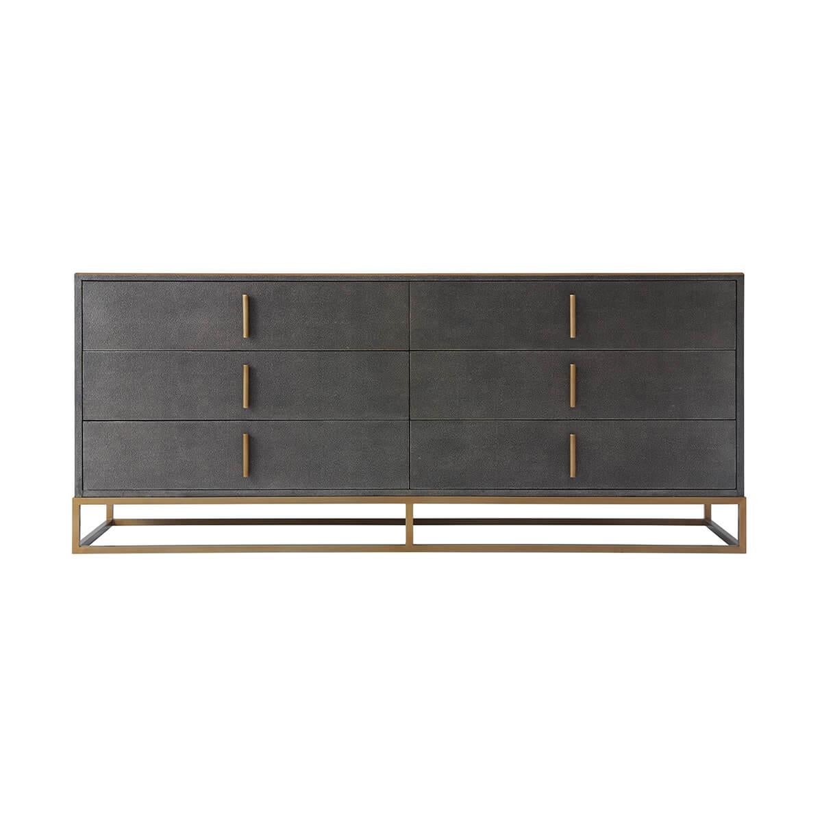 Wrapped in a shagreen embossed leather in our dark tempest smoke finish, with six long drawers and with brushed brass finish hardware and trim, all raised on a cube form brushed brass base.

Dimensions: 72