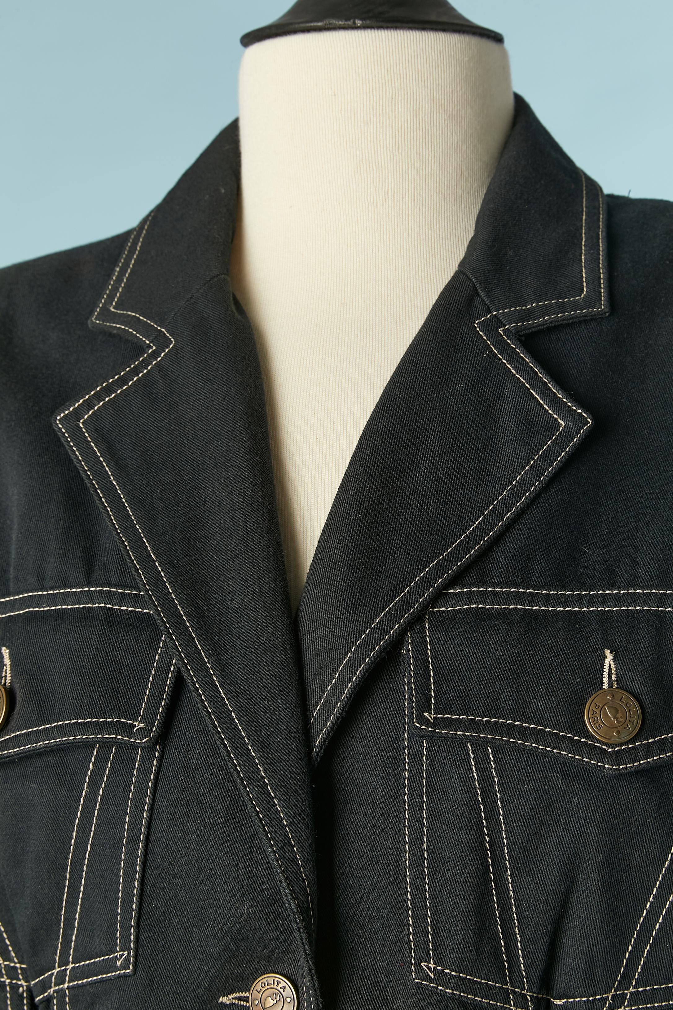Veste en coton bleu marine foncé à simple boutonnage avec lacets sur le devant et au milieu du dos. Surpiqûres blanches, boutons et épaulettes de marque. 
TAILLE 42 (Fr) mais convient à M 