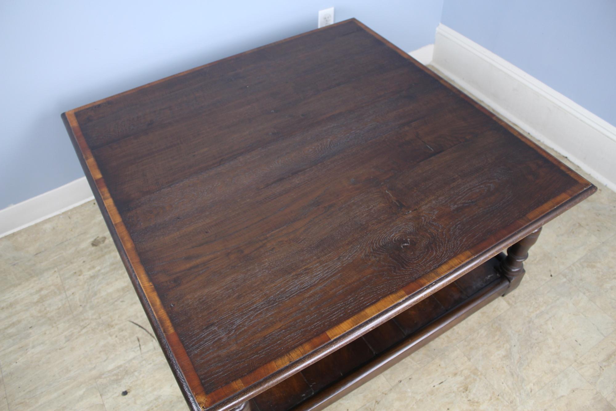 Solid oak, custom made in England, for a great look in the style of a period piece. Well shaped legs to a planked lower shelf. The top has lovely dark oak grain, color and patina, edged with yew for a decorative accent. Solid and strong.