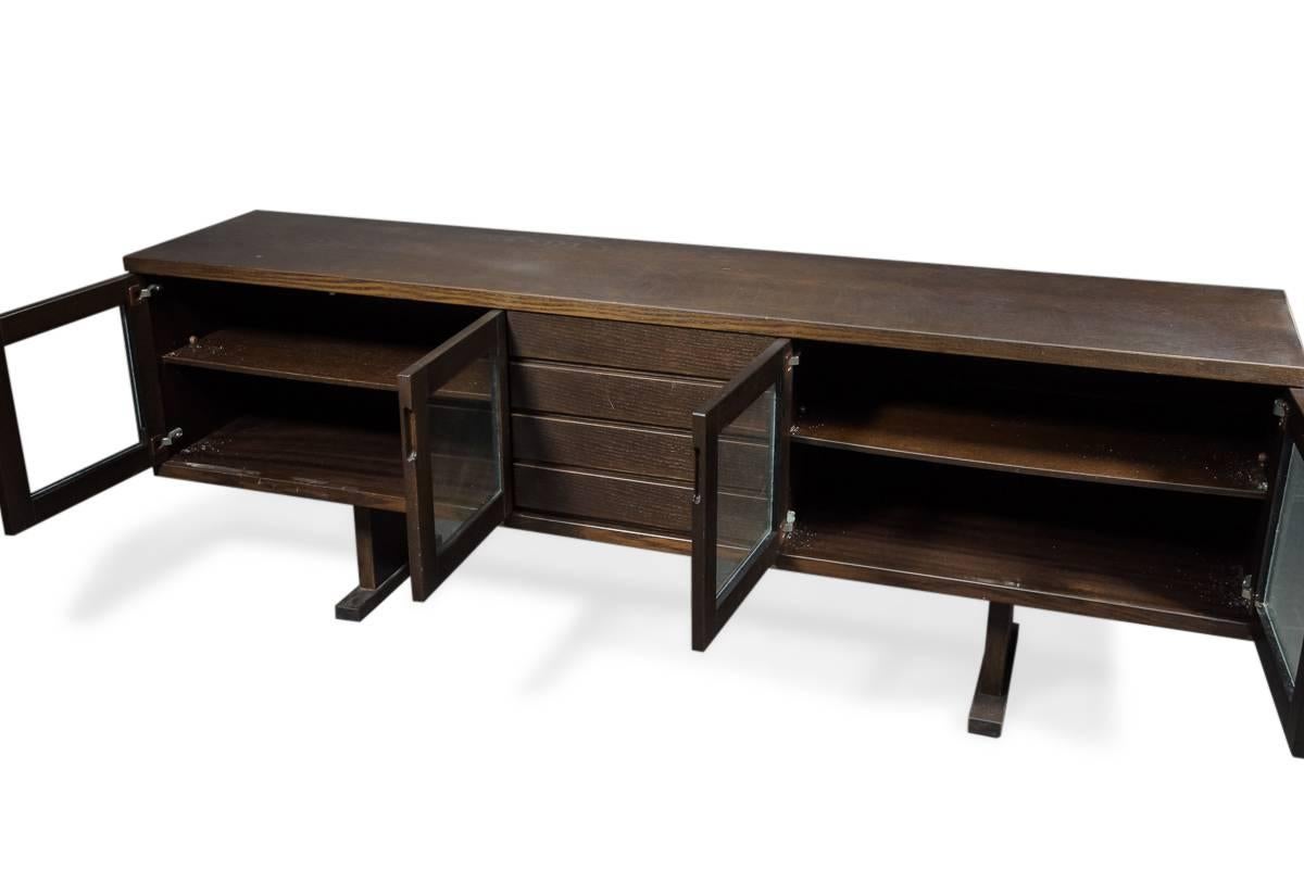 Dark oak sideboard, front with four drawers and two glass doors, overlooking shelves. 
Measures: H 78 cm., L 216 cm., L 46 cm. 
Normal wear, scratches.