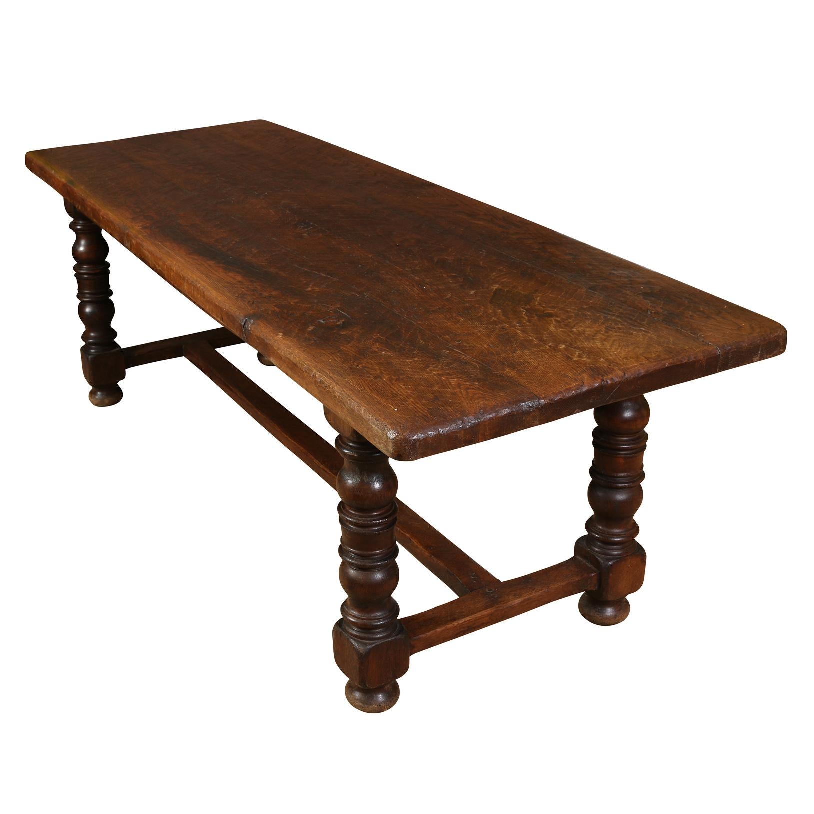 Cette table ajoutera une touche d'originalité à n'importe quelle pièce.  Fabriquée en chêne foncé, la table possède de généreux pieds tournés reliés par un châssis.  Le plateau a des coins légèrement arrondis et la finition a vieilli jusqu'à