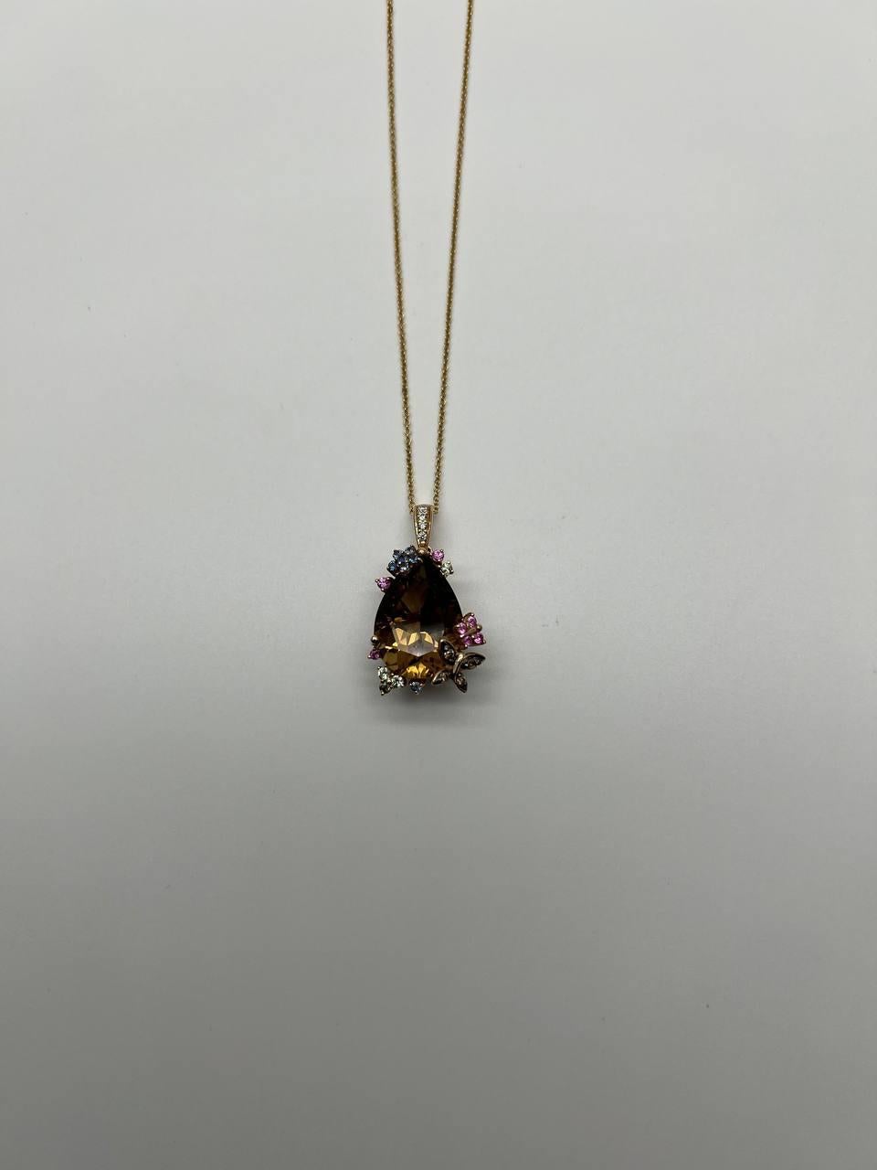Questa splendida collana è caratterizzata da un ciondolo mozzafiato.

Il ciondolo mostra un grande citrino arancione sfaccettato, circondato da intricati motivi floreali ornati da piccole pietre colorate e diamanti.

Realizzato con precisione, il