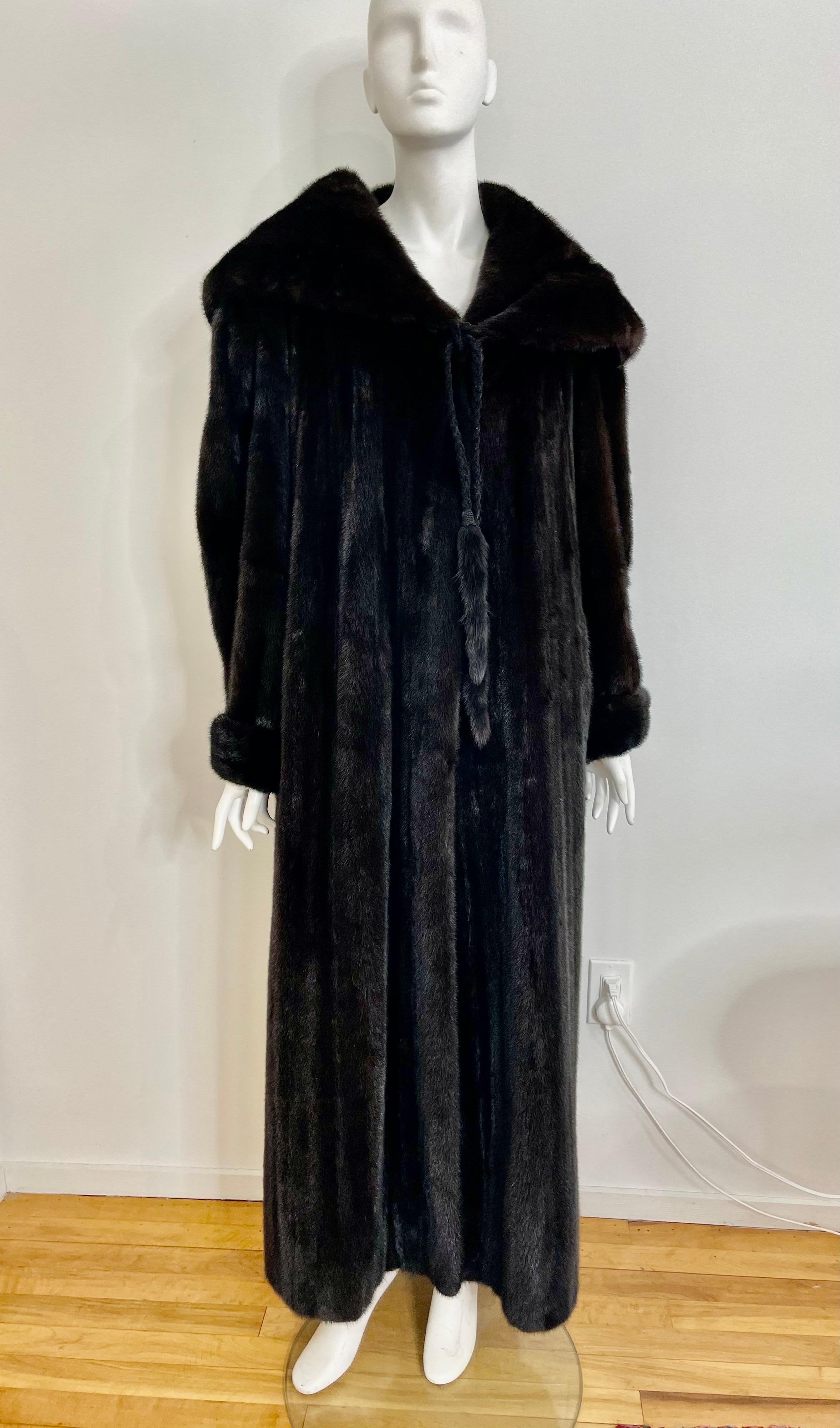 This coat is absolutely stunning. Deep almost Black Mink, with a massive collar. The collar may double as a hood depending on your neck. 3 Clip closures as well as a tassel tie front. Slit pockets. This is labeled a size 8 but will fit up to a 14