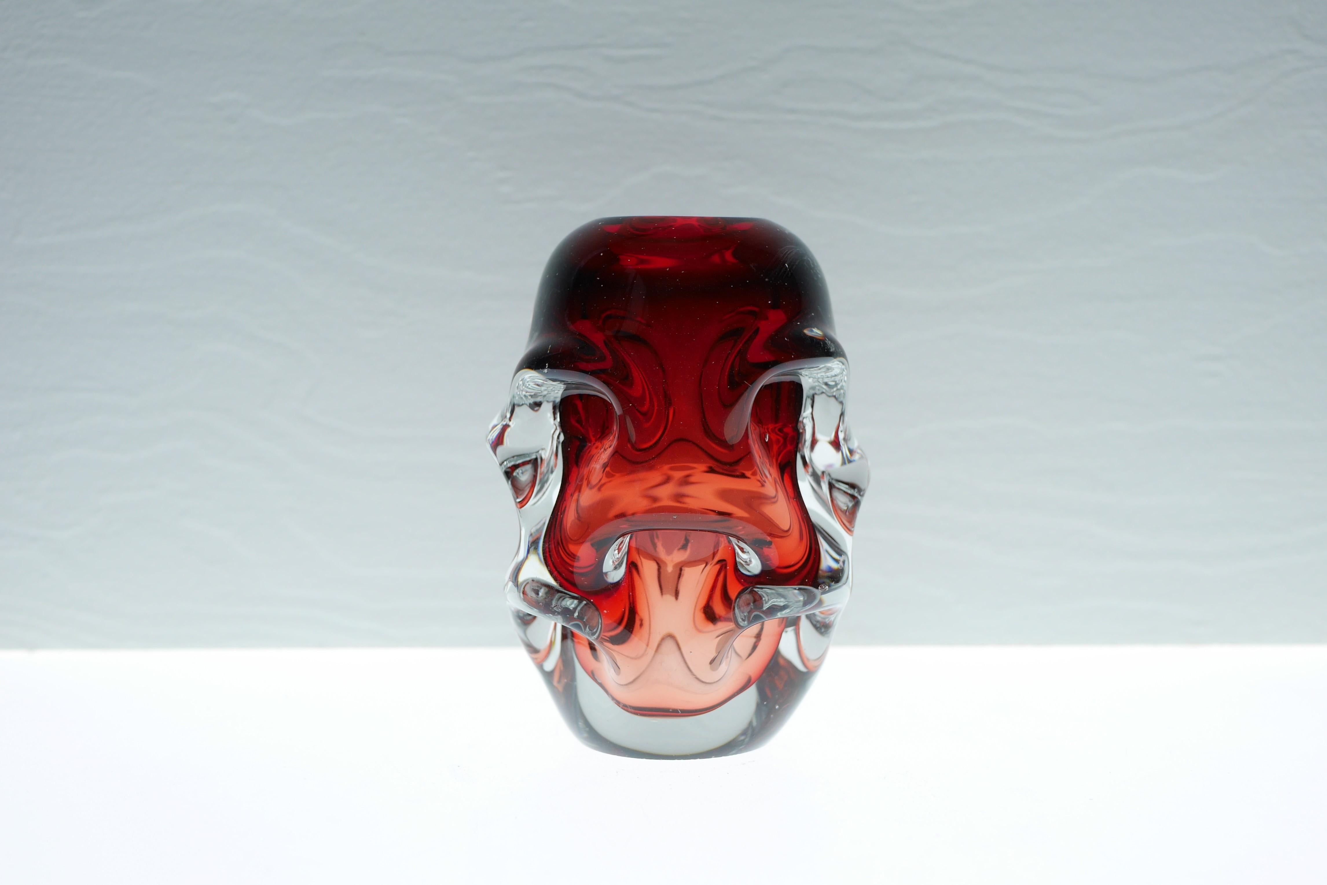 A fantastic ruby red crystal vase made by the talented Börne Augustsson during the 50s. It has a biomorphic shape, yet it is the color that makes this vase so special an amazing a fantastic dark raspberry pink color. This vase is very special and