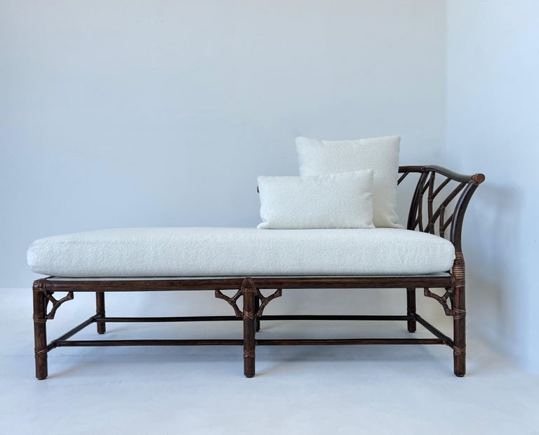 Glamorous 1970’s dark stain rattan bamboo with rawhide and white boucle daybed by McGuire Furniture. 
The frame is in original condition, the cushions have been newly recovered in a white soft boucle fabric. 
Measurements: 60” Wide, 32” Deep, 31”