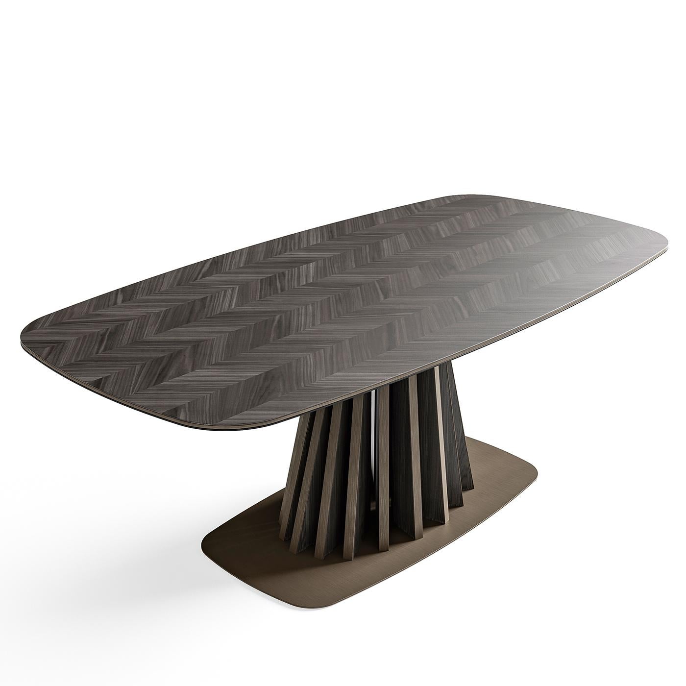 Chic, organic influences shape the inlaid dining table. On a tree-shaped base in walnut wood - available in a dark or light stain - the table stands on a metal plate and is topped with wood veneer in a gorgeous Hungarian herringbone pattern. Top it