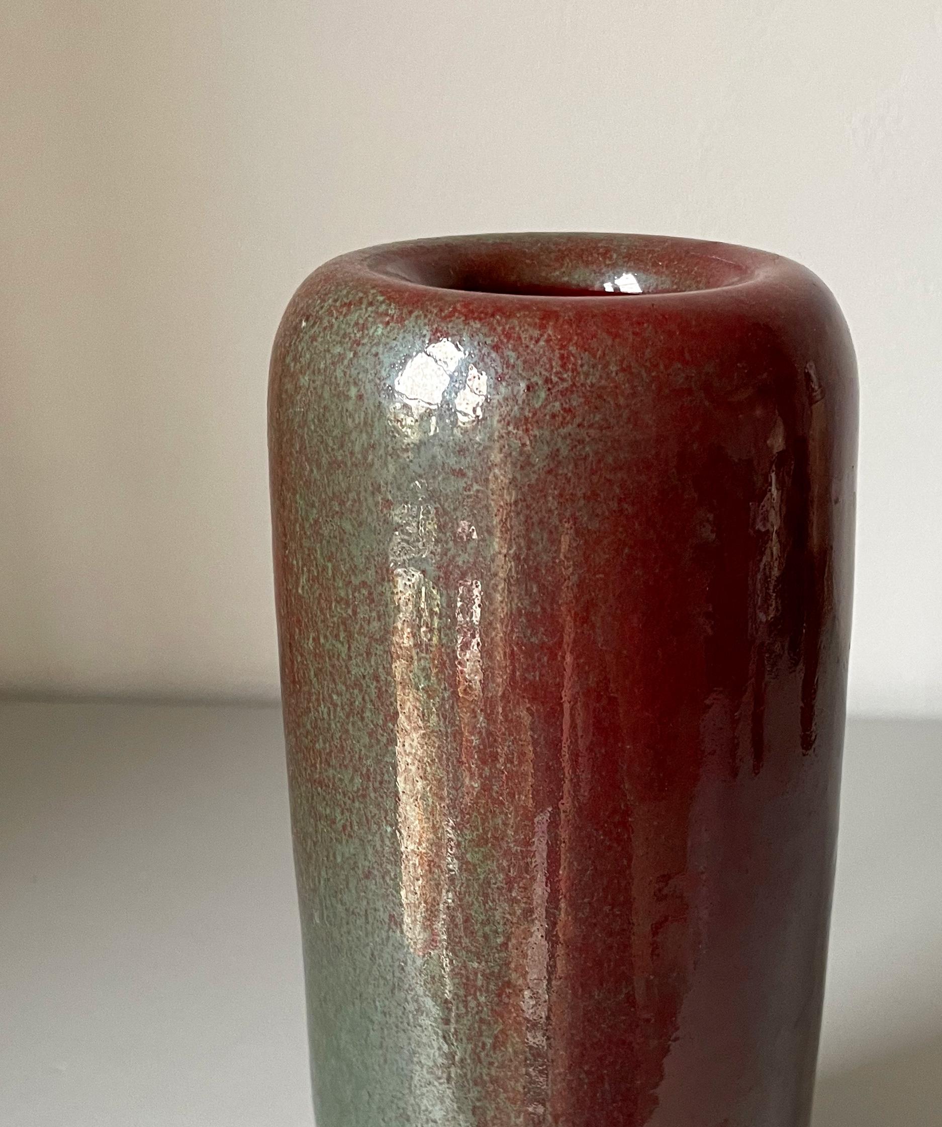 Dark red and green glaze with mother of pearl sheen covers this soft cylinder shaped tall Dutch vase from the 1950s. Signed under base. Beautiful vintage condition. 
Zaalberg, The Netherlands, 1950s.