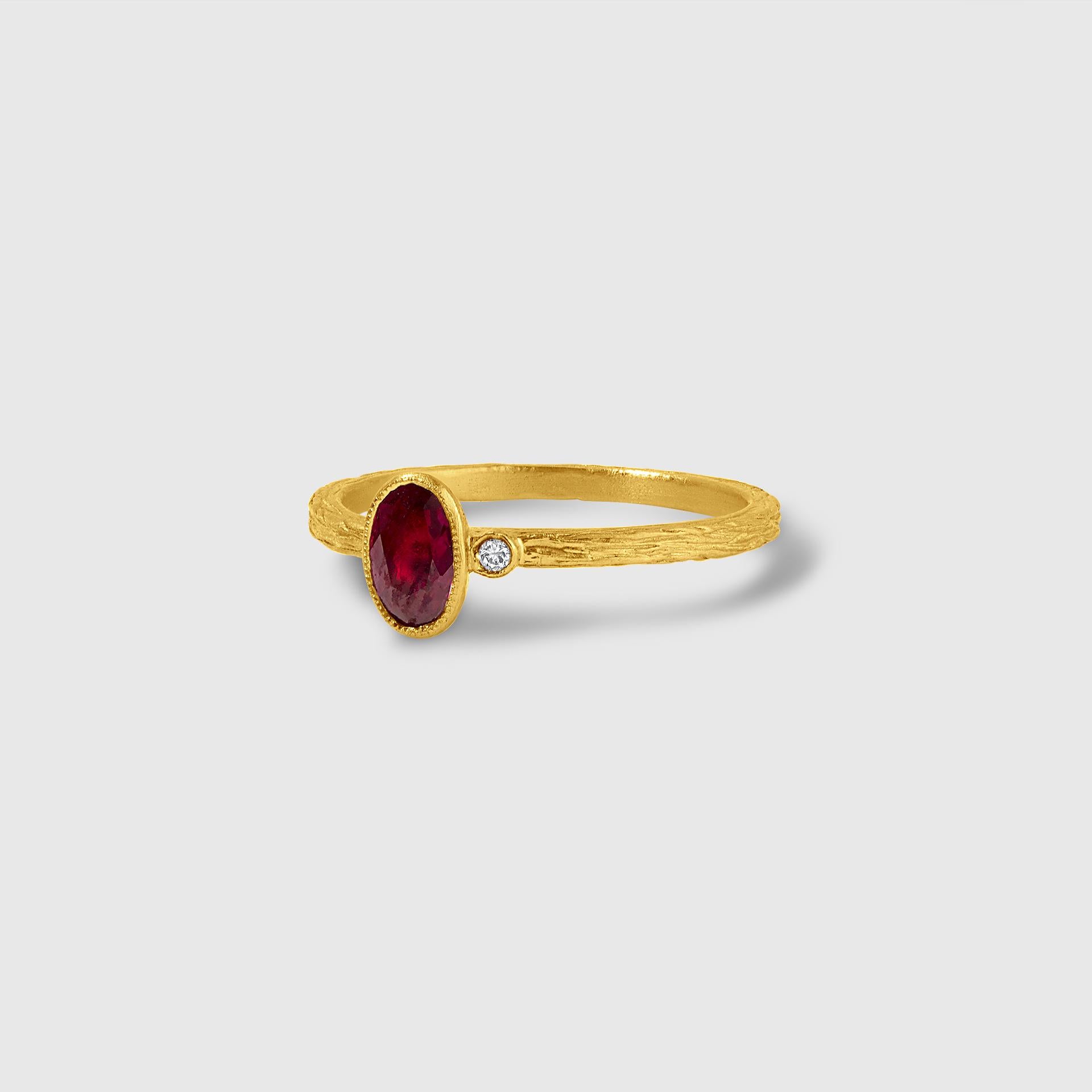24kt Solid Gold Ring with Dark Red Single Ruby Stone by Prehistoric Works of Istanbul, Turkey. Ruby- 0.35ct. Diamond - 0.02cts. Band is slightly textured and makes as a beautiful stacking ring with other bands in the gallery. Size 6 1/2 US