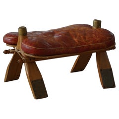 Reposapiés de silla de montar de camello marroquí tapizado en rojo oscuro, Siglo XX, Norte de África