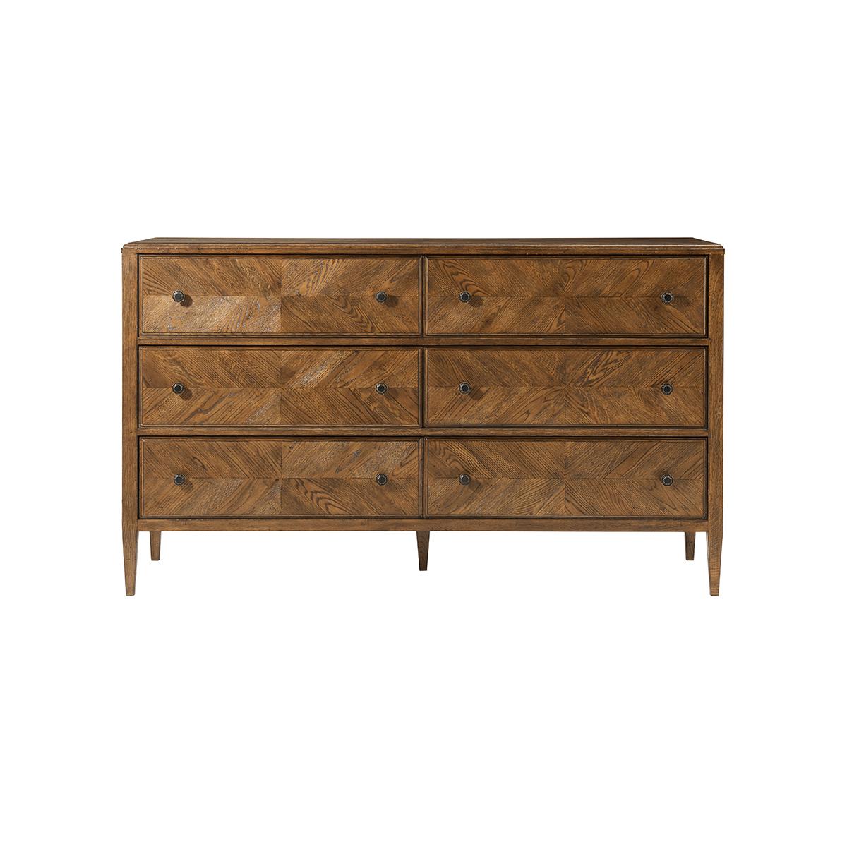 A dark rustic-style oak parquetry dresser with six hand-veneered drawers accented with Verde Bronze finish handles and tapered oak legs. 

Shown in Dusk finish
Dimensions
63.5